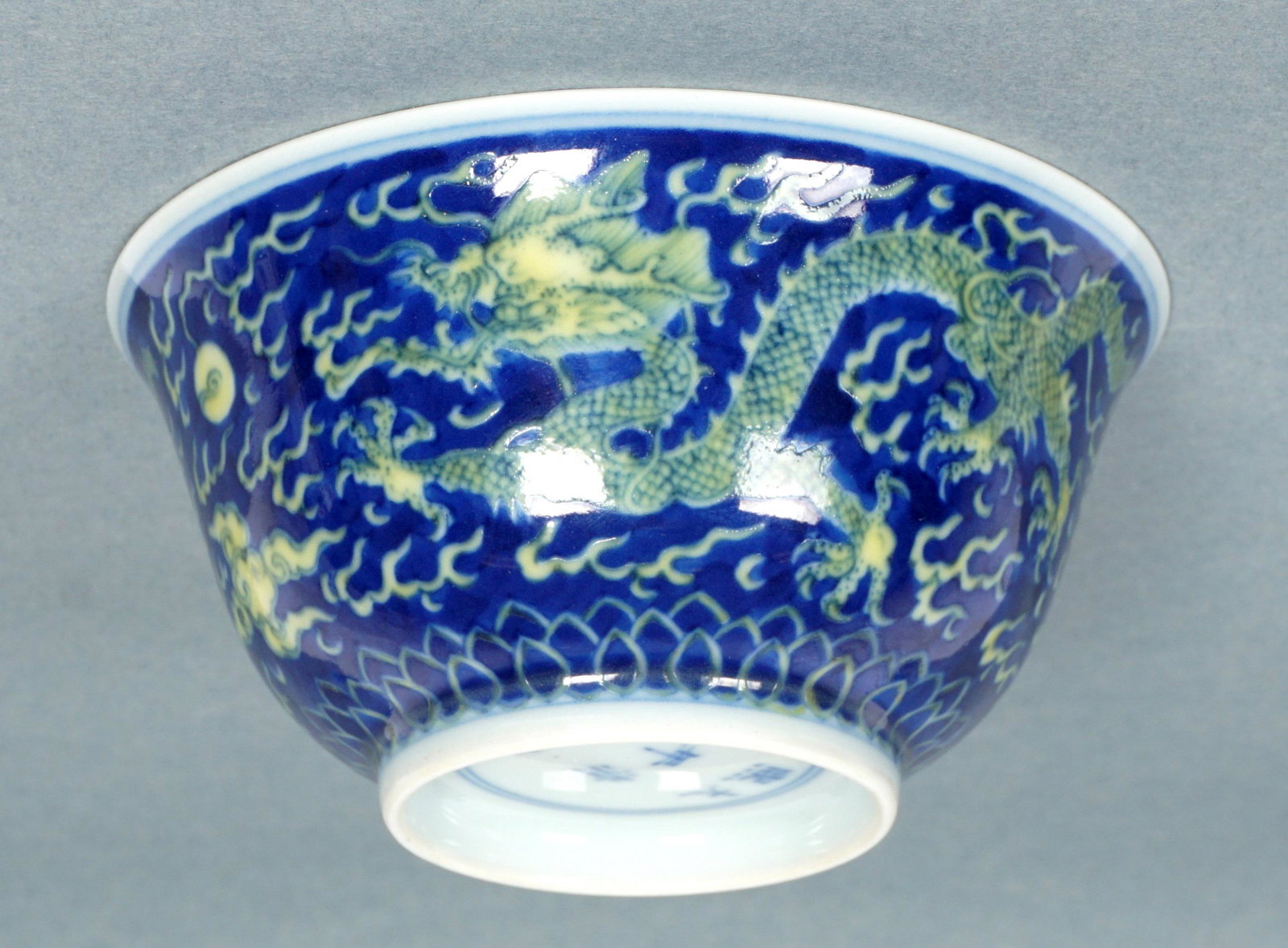 Chinese Kangxi Style Blue & Yellow Dragon Bowl: Blue ground exterior decorated with two five-towed dragons, pearls and smoke, matching interior medallion. Marked on base with six character Kangxi mark. Bears a U.A. Leavett-Shenley collection tag. O