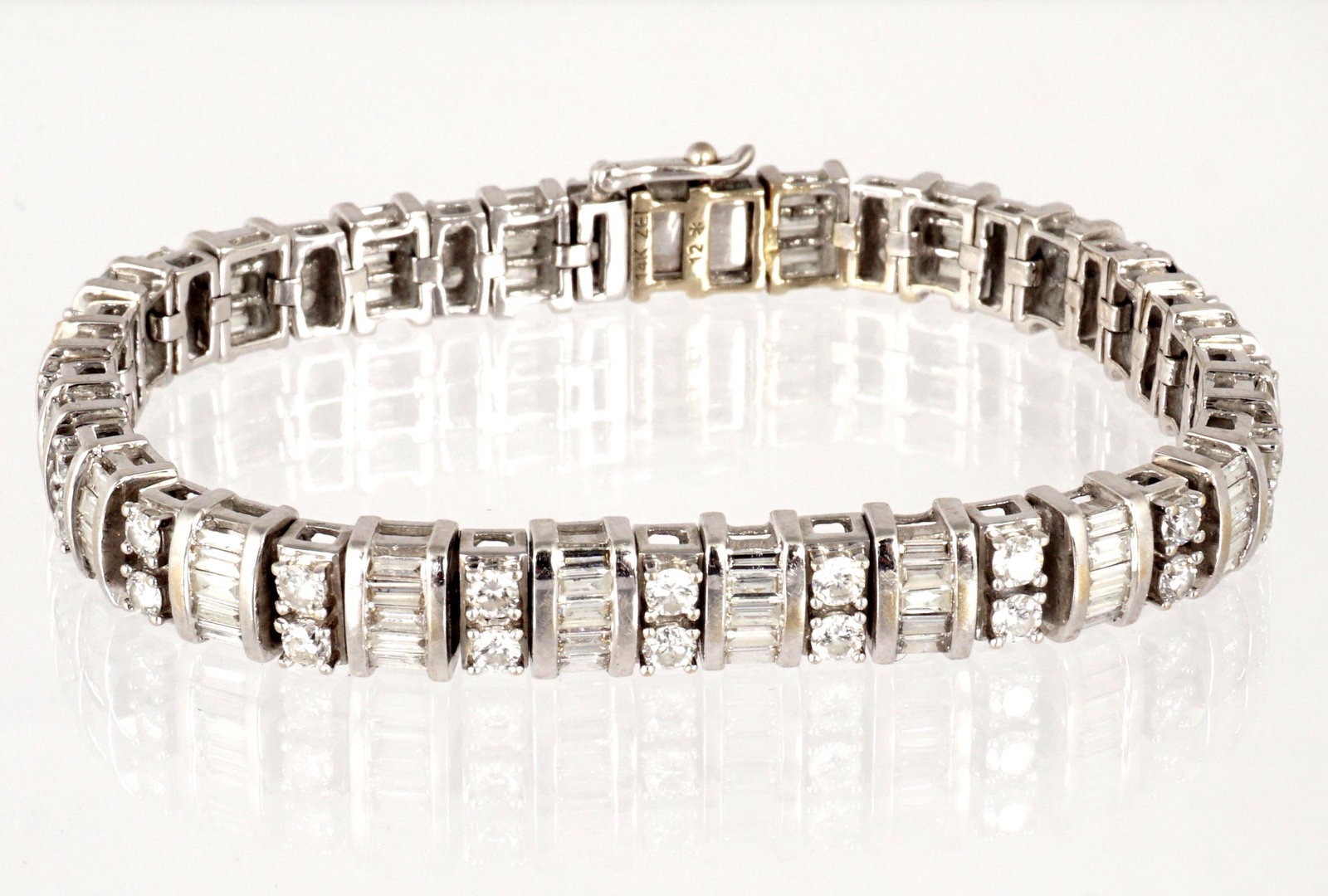 14k White Gold and Diamond Tennis Bracelet: 14k white gold bracelets, alternating links with two round diamonds and five baguette diamonds each, total 44 round, 105 baguette, approx. 7 ctw. , 6 5/8" long, marked 14K ZEI, 12*. Approx. 21.6 grams