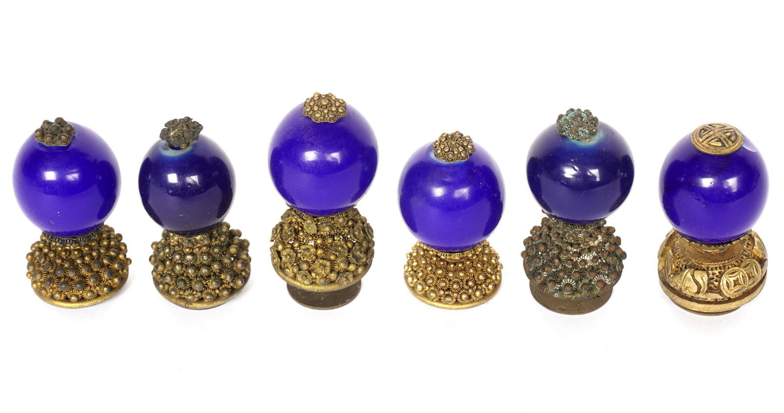 Six Chinese Qing Fourth Rank Hat Finials: An assembled collection of six, each with sold blue Peking glass globes, assorted design pierced bases, largest measures 2.5" h., smallest 2.25" h. Condition: One with chip at top.
