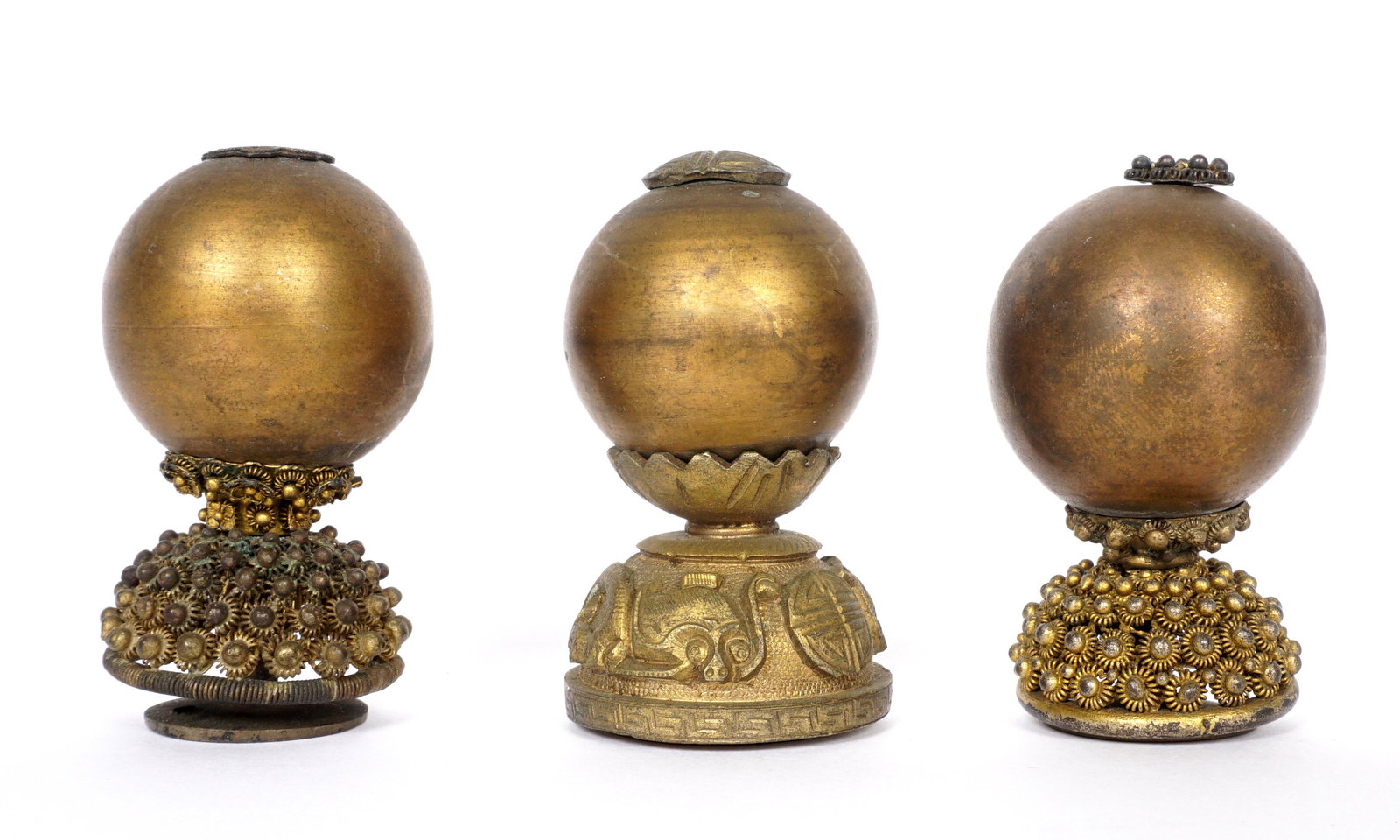 Three Chinese Qing Seventh Rank Hat Finials: An assembled collection of three, each with brass globes above pierced and raised design bases, 2.25" h. One globe with ding to sphere.