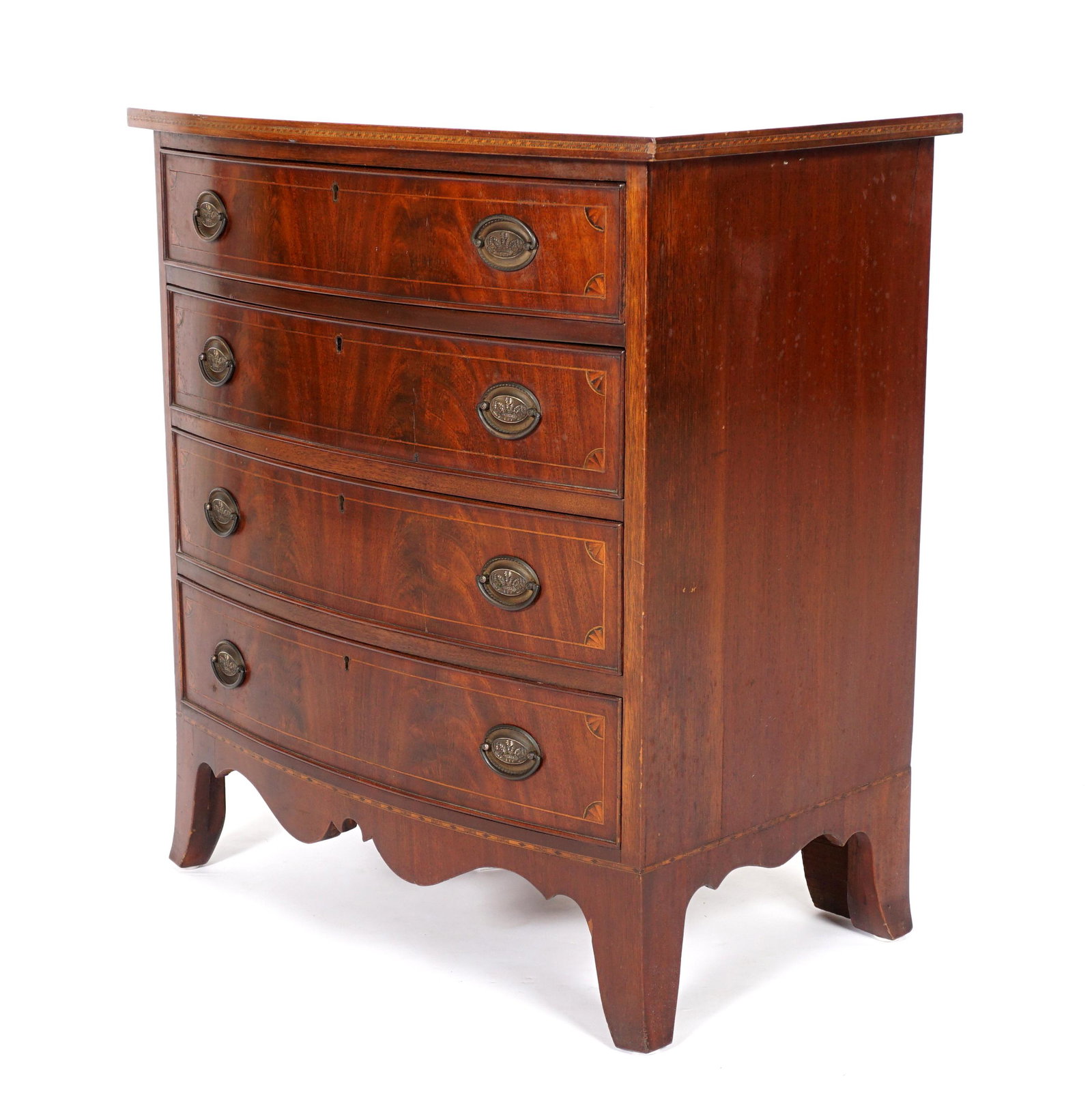 American Mahogany Bowfront Chest: Circa 1920, four graduated drawers with string inlay and paterae corners, embossed brass pulls, scalloped skirt, overall 32" h. x 28.25 x 18.5". Condition: Scratches, age split in top.