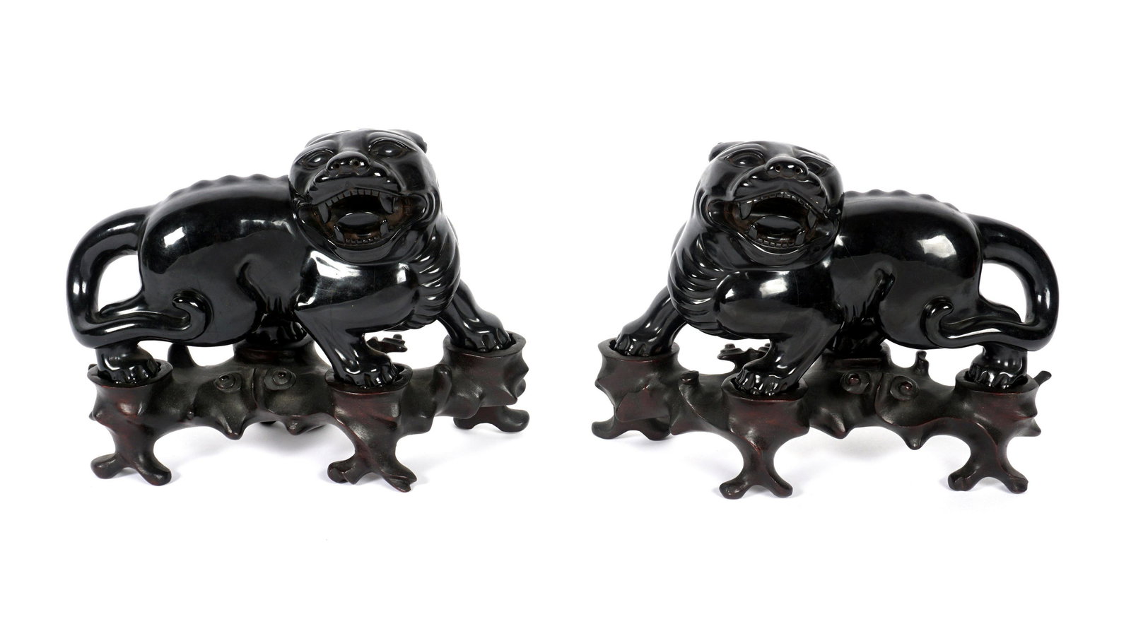 Pair Chinese Faux Amber Foo Dogs with Stands: Pair composite faux amber foo dogs, each measures 4.5" h. x 8" x 3". Sold with fitted wood stands, one stand missing a foot.