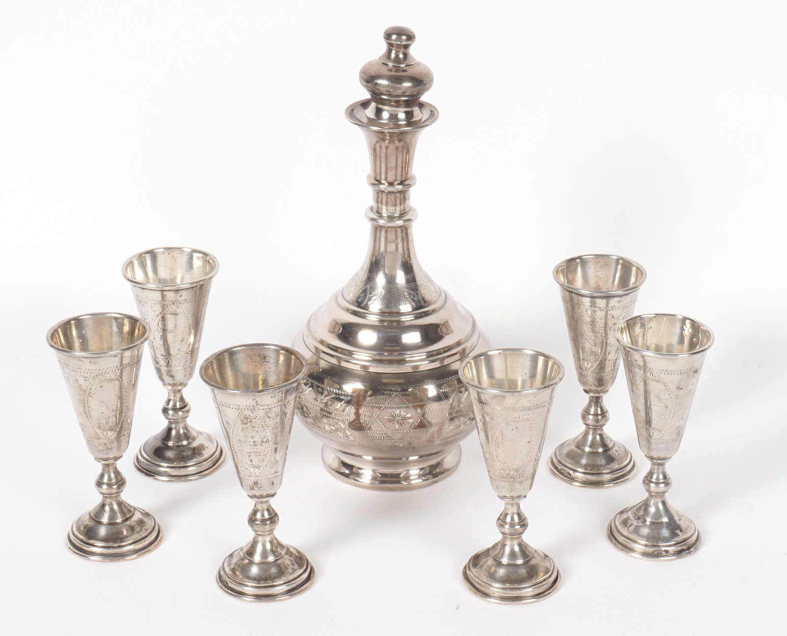 Sterling Silver Decanter and Six Cordials: Seven pieces total to include engraved decanter marked Sterling AG, 8.75" h. x 4" dia. Six matching cordial cups, 4" h. Approx. 15.2 troy oz. Condition: Minor dings.