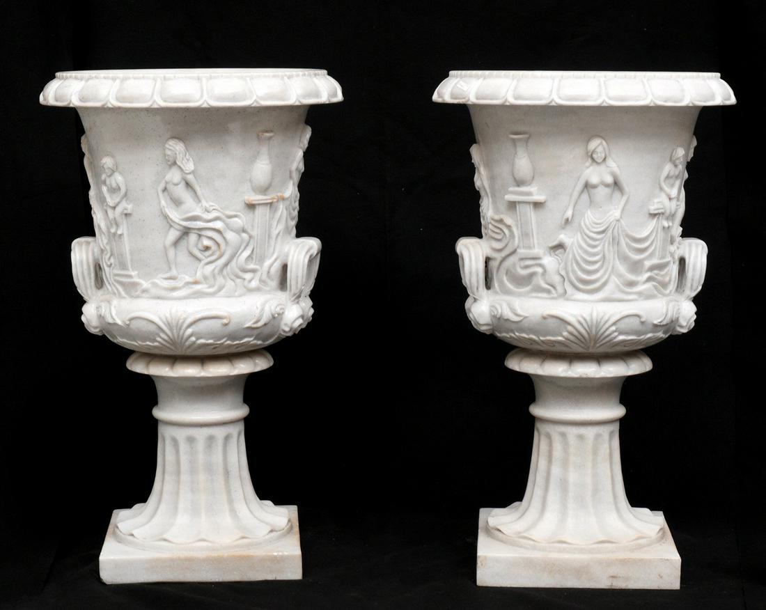 Pair Large Carved Marble Garden Urns: Neoclassic motif carved marble bodies, each on scalloped carved stands with square base. Overall 39.5" h. x 24". Condition: One with crack repair.