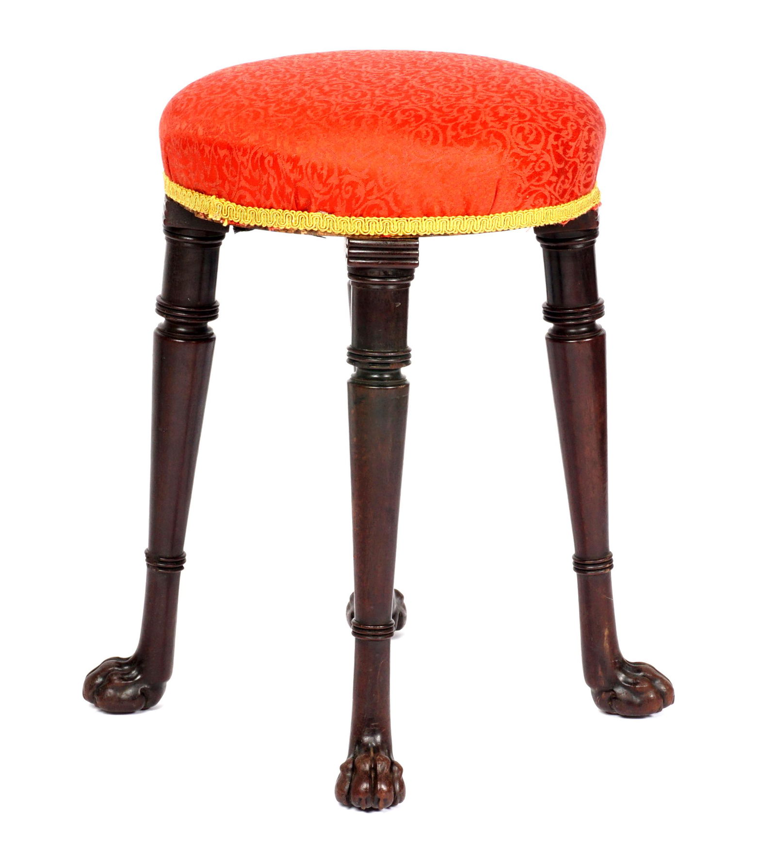Irish Upholstered Stool with Paw Feet: Red upholstered top with gold trim, turned tapered legs ending in paw feet, overall 19.75" h. x 17" dia. Condition: Scratches and chips to legs.