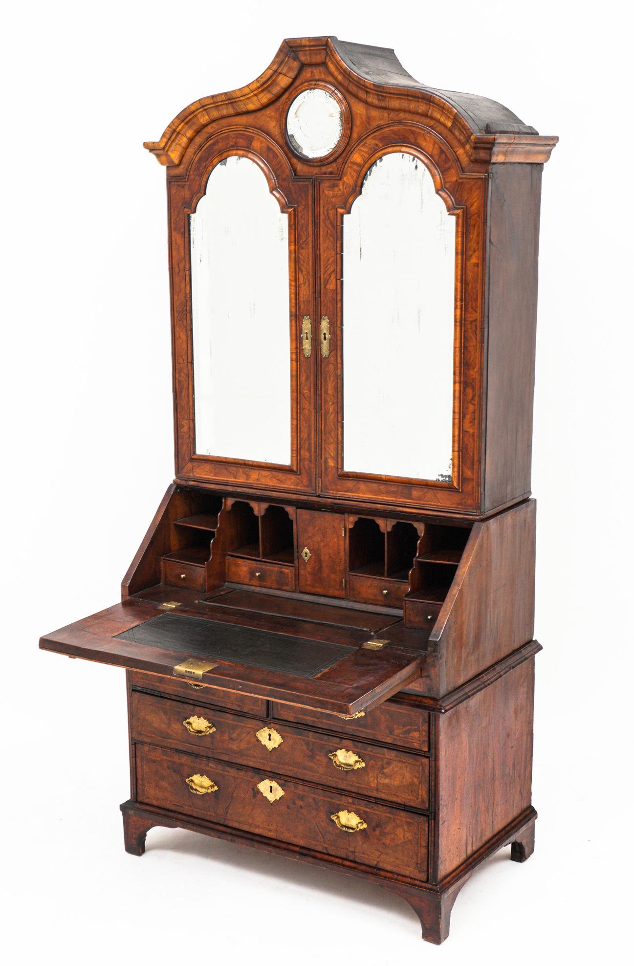 Early English Chippendale Burl Walnut Secretary: Serpentine arched molded cornice over top center round mirror, two shaped mirrored doors. Fitted interior with multiple shelves, cubbies, pigeon holes, and drawers. Slant fall front base over two slid
