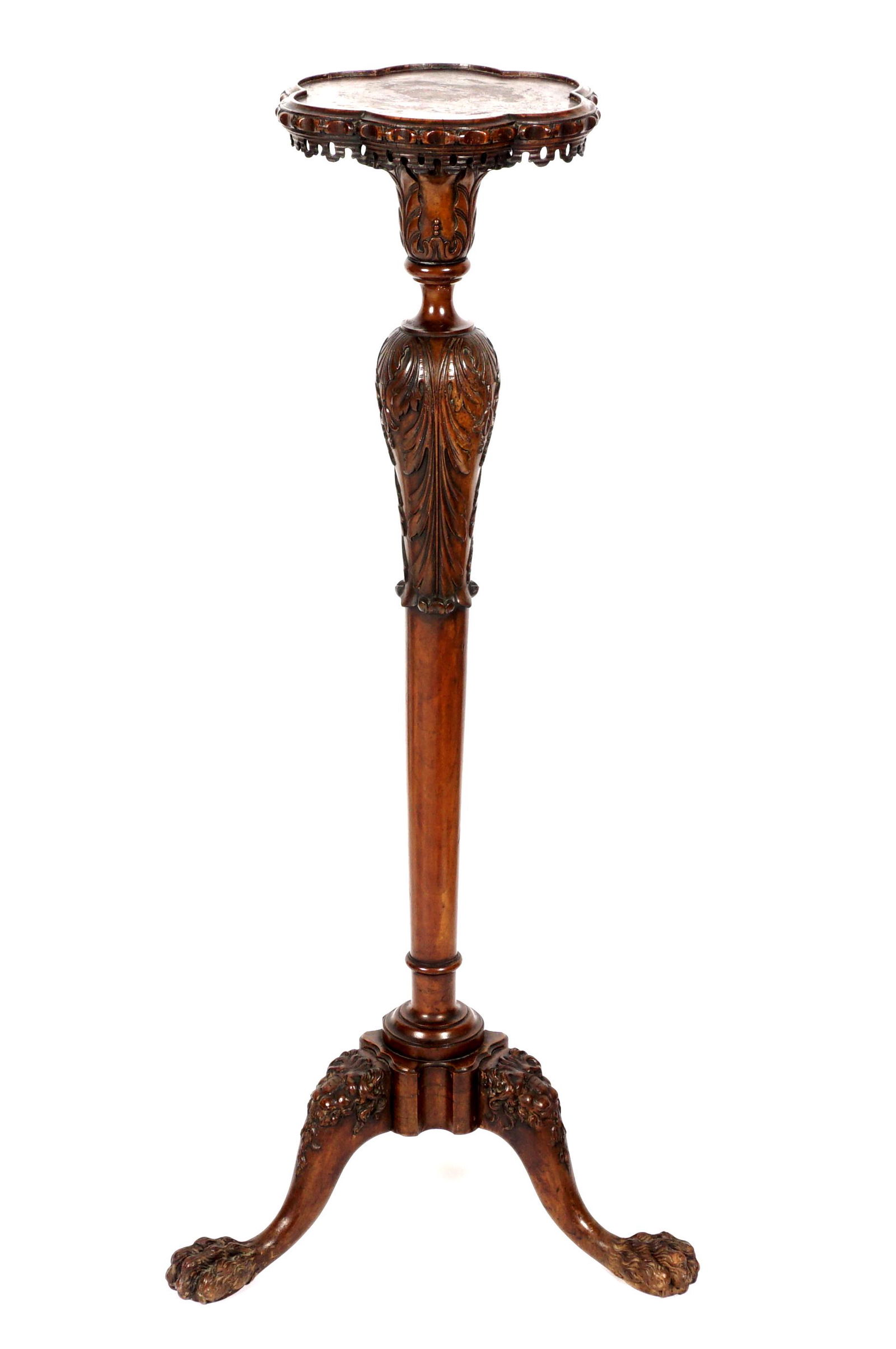 18th / 19th Century Irish Mahogany Torchiere: Floriform top with reticulated carved apron over carved acanthus leaf decorated shaft, three splayed feet with figural lion heads at knees, ending in paw feet. Overall 51" h. x 13.5" dia at top, 24" d