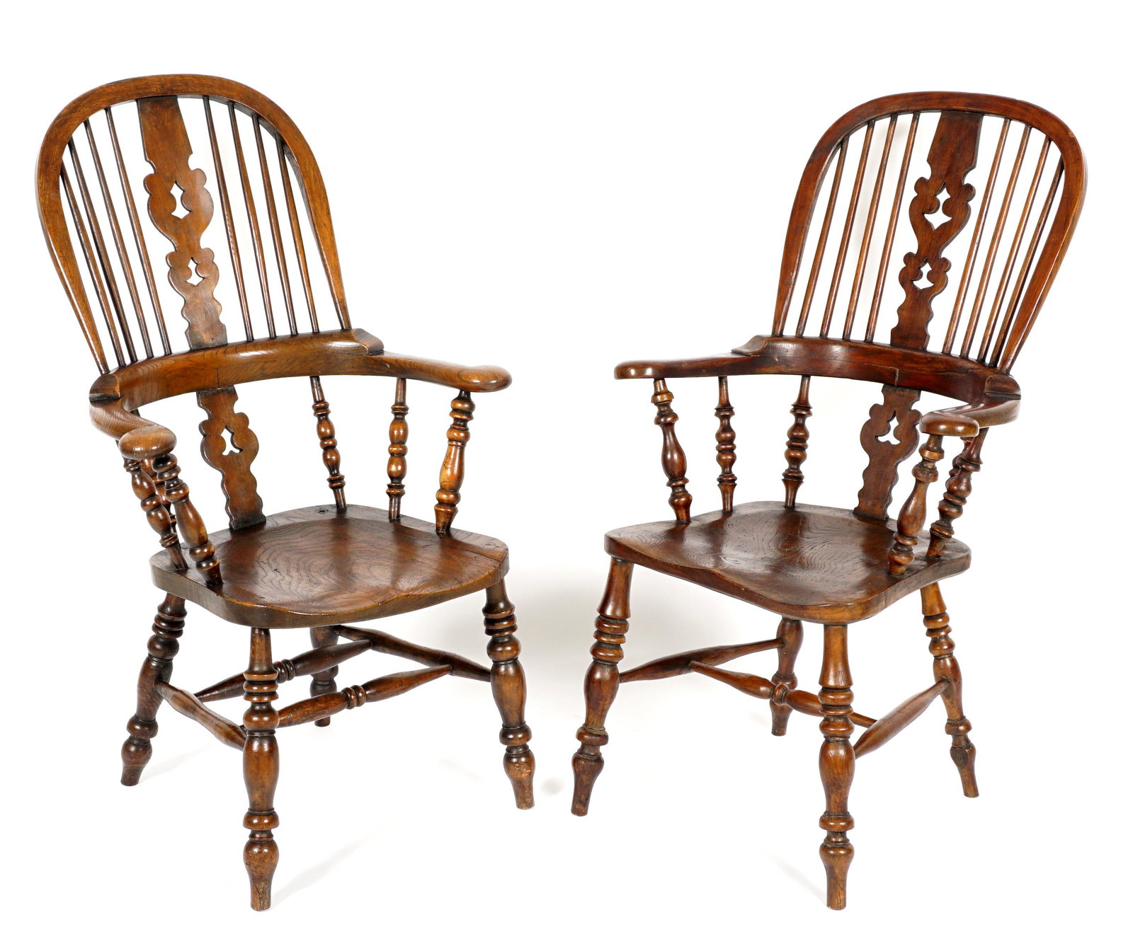 Pair 19th Century English Windsor Arm Chairs: Reticulated carved center back splat,, eight turned spindles, shaped arms, turned arm supports. Saddle seat, turned legs ad stretchers. Overall 44.25" x 25.5" x 27". Wear consistent with age and use.