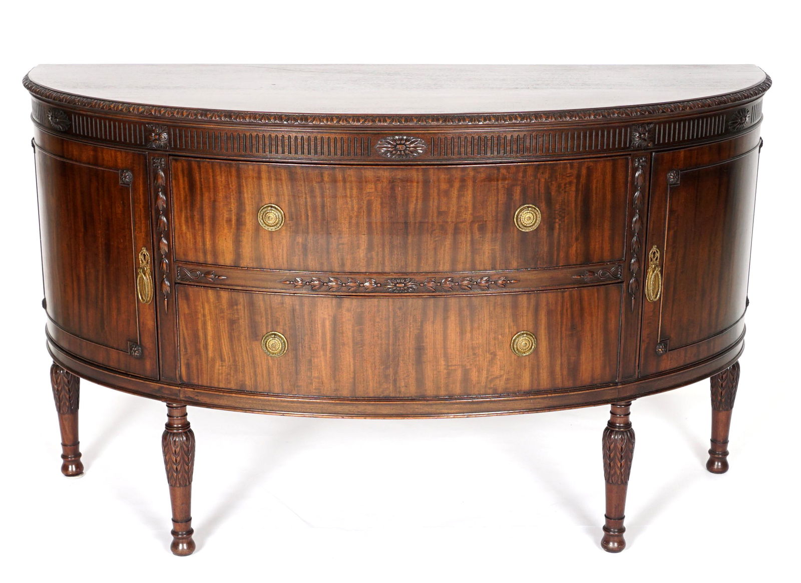Adams Style Mahogany Demilune Sideboard: Early 20th Century, demilune top with carved trim. Conforming case with two drawers flanked by door either side. Carved bellflower and floral decoration, on carved and turned legs. Overall 39" h. x 65