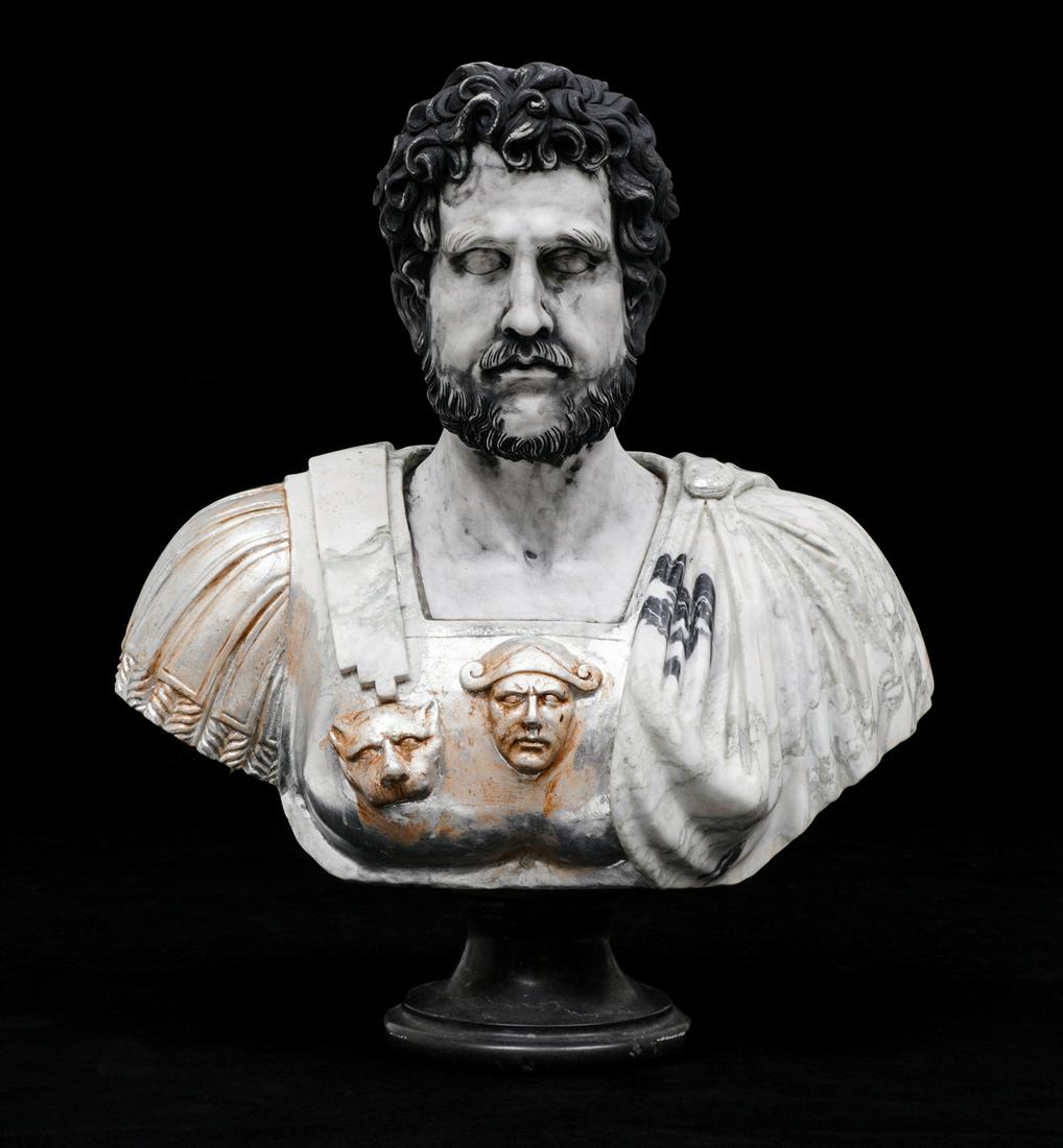 Carved Marble Bust of Roman Statesman or Scholar: Roman bust of a man with curly hair and beard, variegated marble chest plate, black marble plinth. Overall 33" h. x 29.5" x 13". Traces of black paint remain in hair, face, and chest.