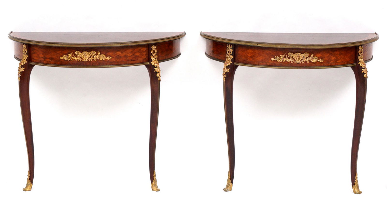 Pr French Ormolu Parquetry Top Demi Lune Consoles: Pair of demi lune console tables, parquetry inlaid tops, parquetry skirt with applied ormolu mask and foliate decoration, Shaped legs, ormolu decoration at joints, overall 29.75" h. x 35.5" x 17.75".