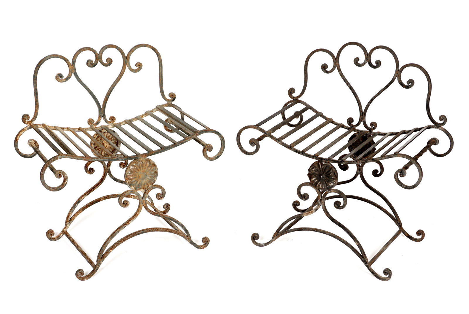 Pair English Wrought Iron Garden Benches: Wrought iron garden benches / seats, heart in scroll backs, shaped seats, floral medallions, scroll legs, stretchers, and feet. Overall 29.5" h. x 28" x 14.5". Condition: Surface rust, obvious signs o