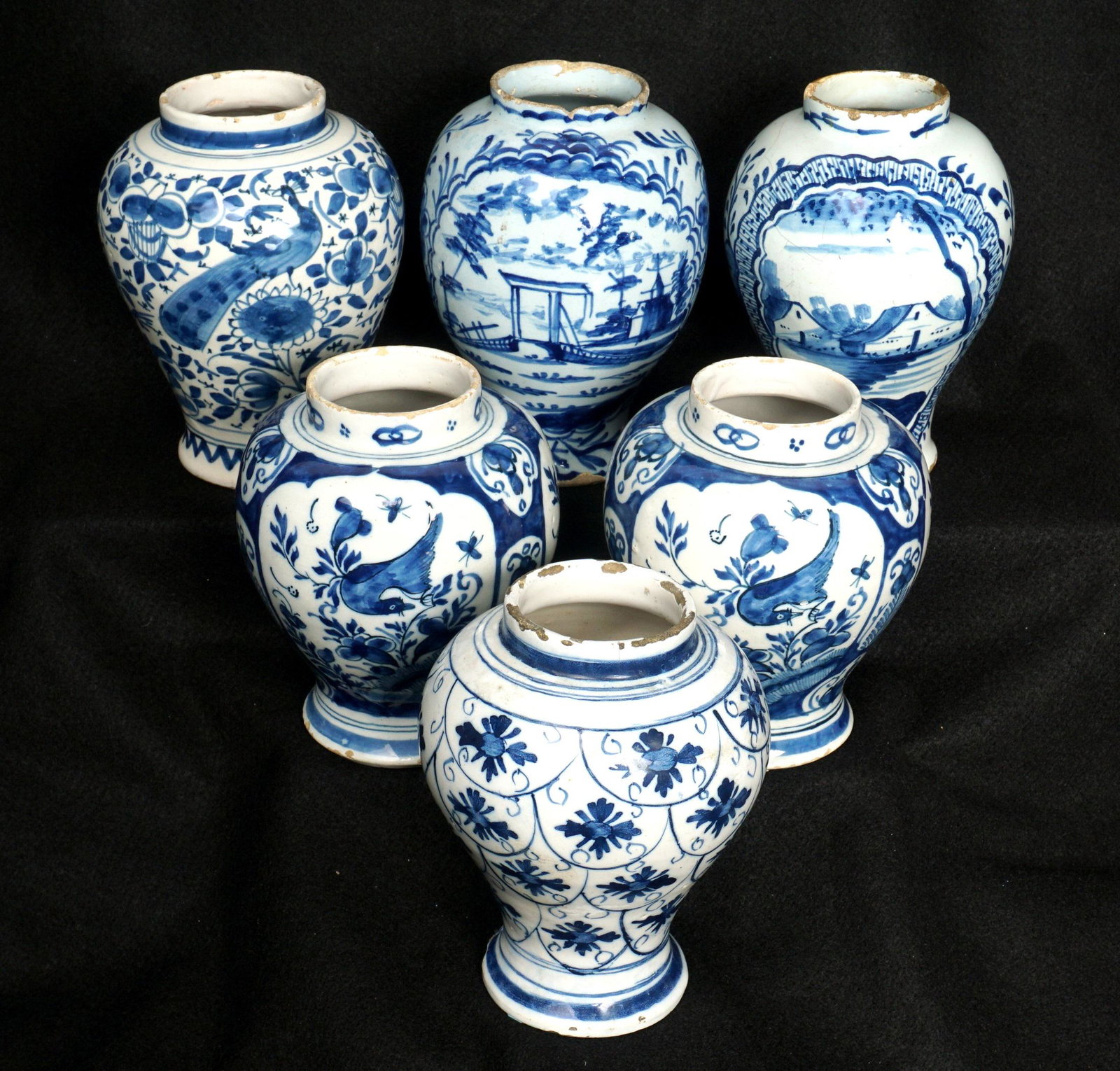 Six Delft Blue Decorated Jars: An assembled collection of six pieces total, assorted decoration to include buildings in landscapes, birds, floral, and foliate motifs. Tallest measures 6.5" h. x 4.75". Condition: Chips, cracks, craz