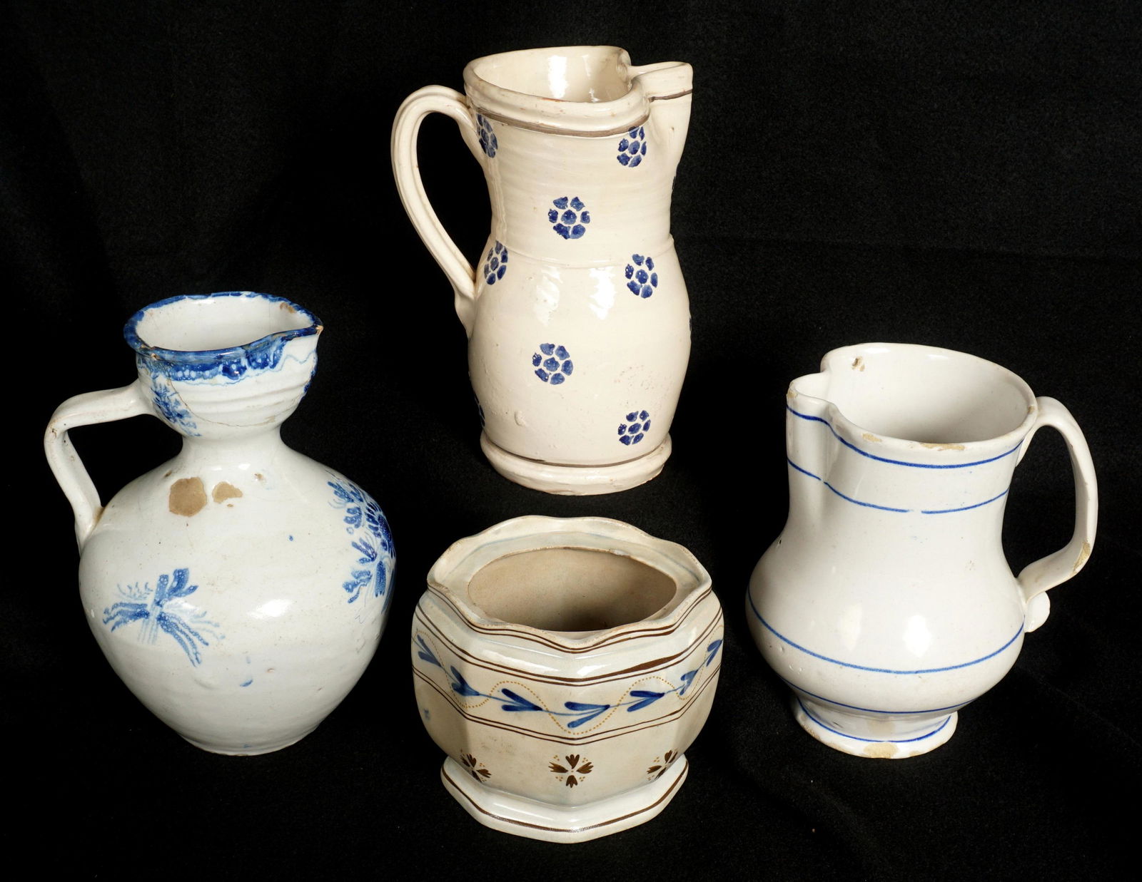 Four Delft Blue Pitchers and Box: An assembled collection of four pieces total to include 1) Pitcher with pinched rim, blue line decorated, 6.75" h. x 6.5". 2) Cream ground pitcher with pinched rim, floral medallions, 8" h. x 5.5". 3)