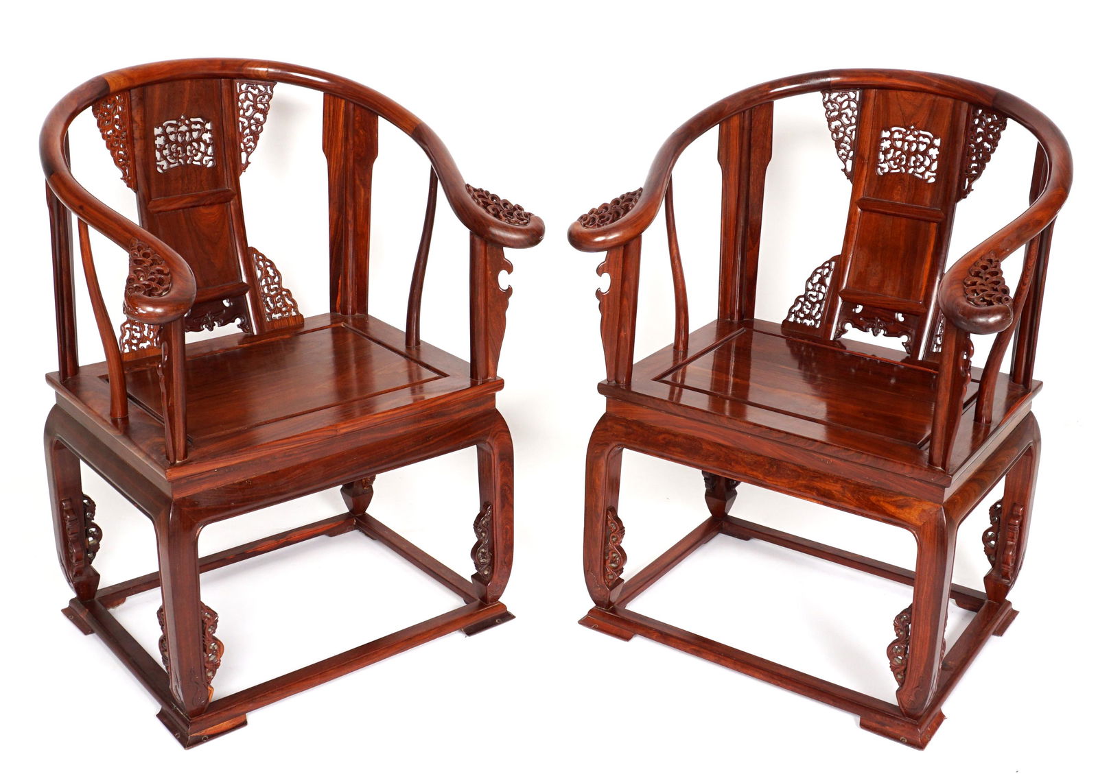 Pair Chinese Huanghuali Horseshoe Back Arm Chairs: Richly grained Huanghuali imperial chairs, each chair with horseshoe back top rail ending in scroll hand holds. Three panel shaped backsplat, ornate and delicate pierced carved foliate decoration, pan
