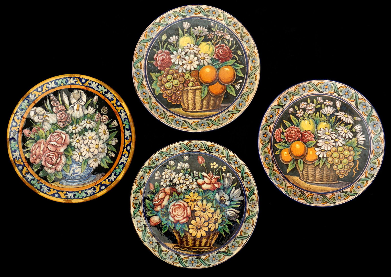 Four Antique Spanish Majolica Faience Plates: Four polychrome floral and fruit motif plates marked Fabrica Ramos Rejano, Sevilla, Spain. Each plate 10" dia. Condition: All with chips and minor decoration loss, one with substantial crack repairs.