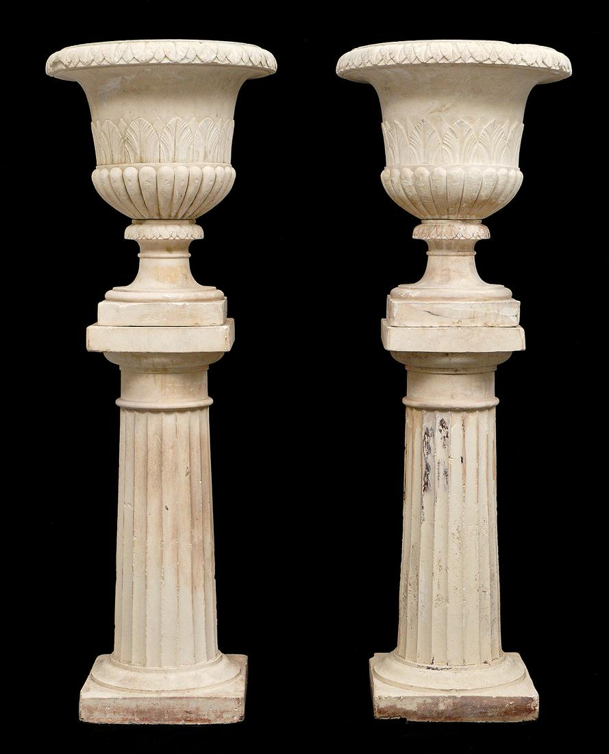 Galloway Style Neoclassical Terracotta Garden Urns: Pair of terracotta neoclassical terracotta urns on stands. Bell for urns with foliate designs, fluted pedestal base, overall on pedestal measures 53.25" x 18.5". Condition: Chips.