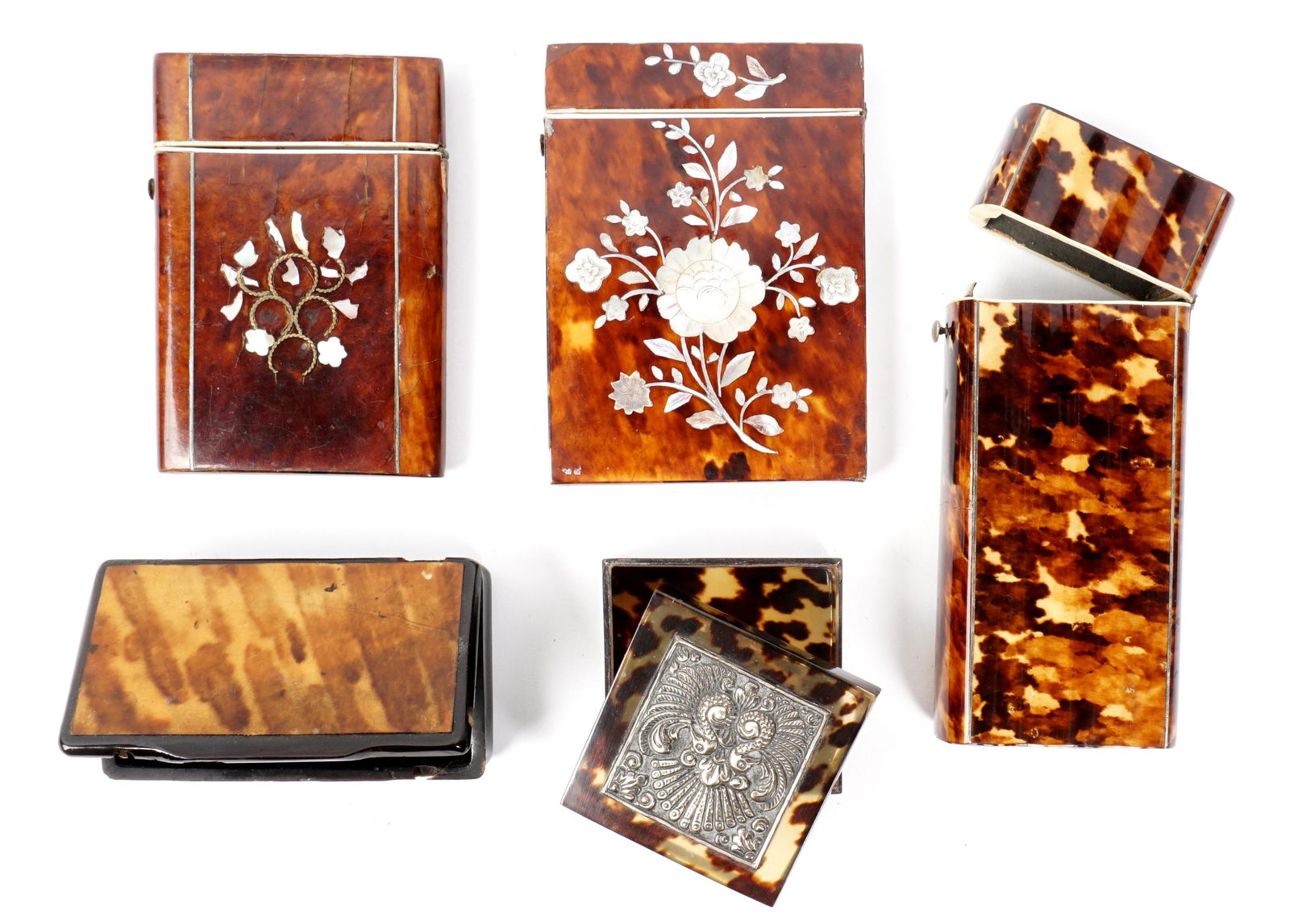 Five Tortoise Shell Boxes and Cases: Five pieces total to include 1) Cigar case with ribbed front and back, hinged lid 5" x 2.25" x 1.25". Note small chip at base. 2) Mother of pearl inlaid card case, hinged lid, 4" x 3". Note chips and