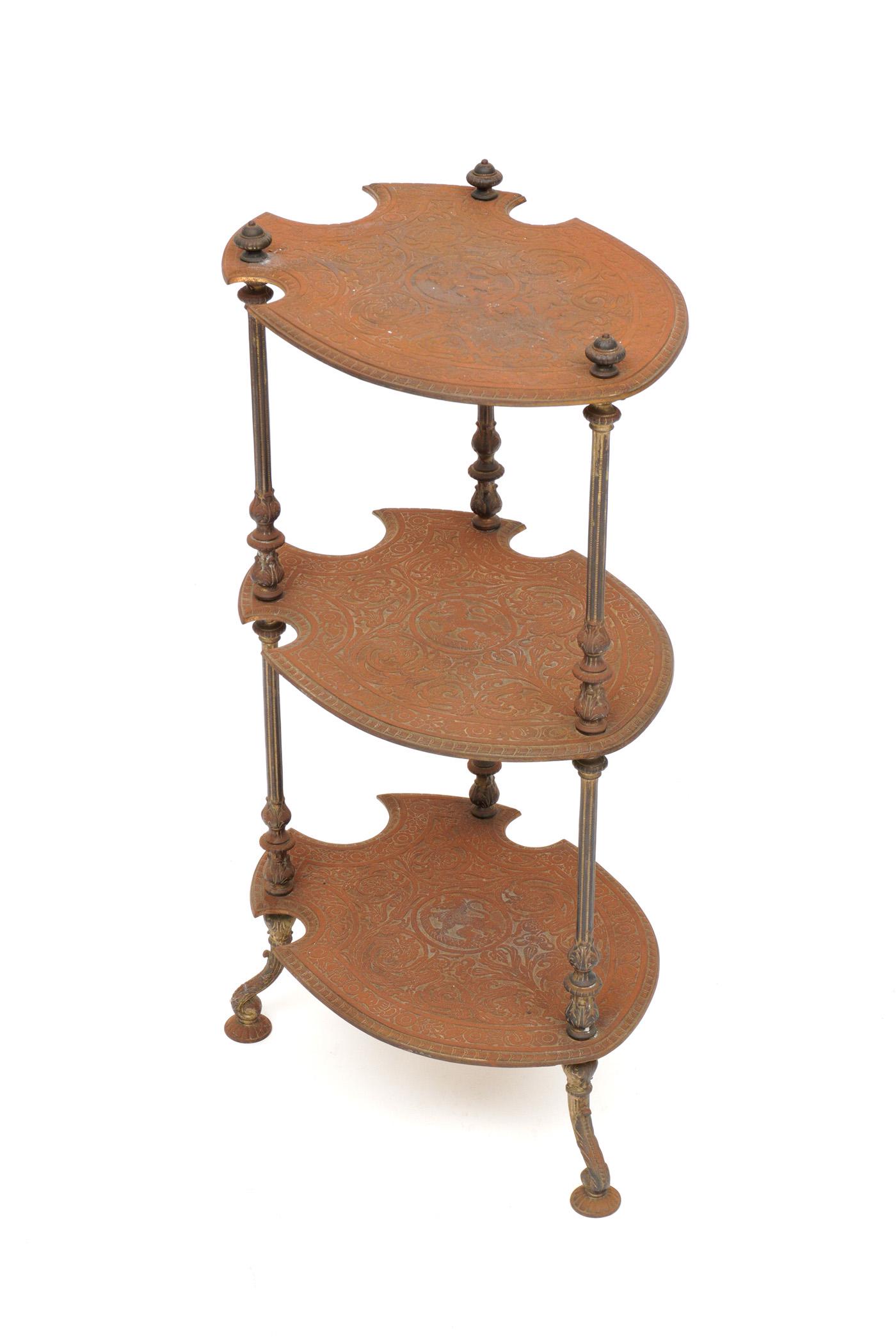 Antique Bradley & Hubbard Coat of Arms Side Table: Three tier cast iron side table, each tier in heraldic shield form, fluted supports, on three feet. Overall 31" h. x 17.5" x 12.5". Condition: Surface rust.