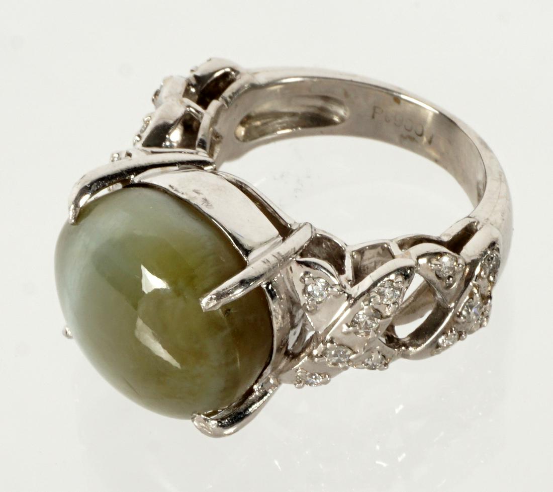 Platinum Cat's Eye Chrysoberyl and Diamond Ring: Platinum band ring, prong set center oval cat's eye chrysoberyl, approx. 16.7 cts., cross X design sides with accent diamonds, approx. .27 ctw. Size 5.5. Approx. 15 grams inclusive.