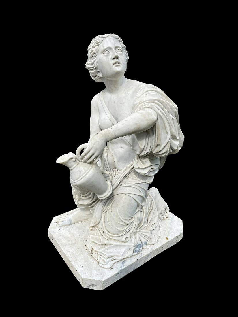 Marble Garden Sculpture Neoclassical Woman: Figure of a kneeling semi nude neoclassical woman holding a pitcher or ewer, no visible signature, overall 47" h. x 23.5" x 32". Condition: Obvious signs of weathering. Shippers Note: Requires several