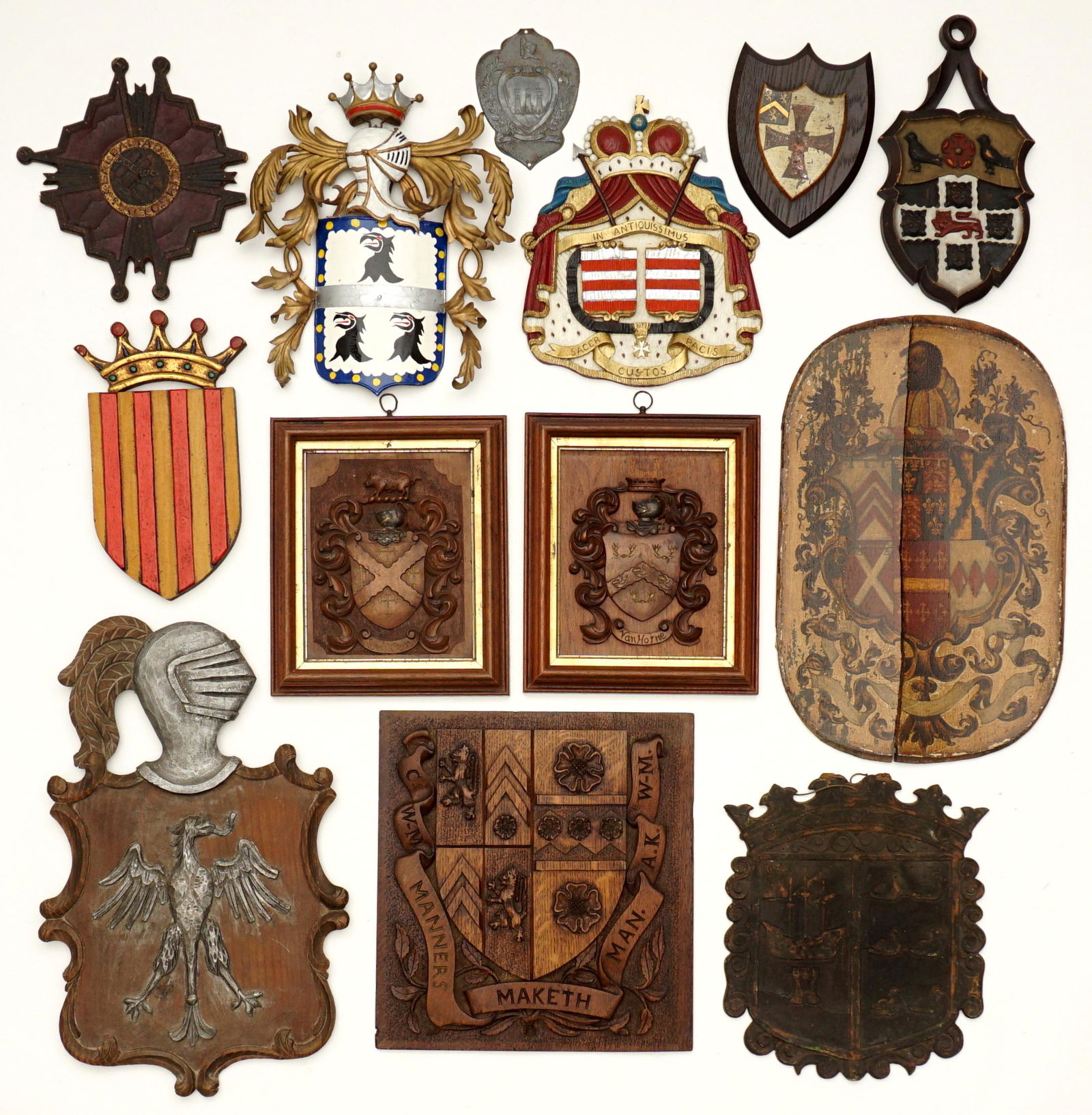 Collection of 13 Antique Coat of Arms Wall Plaques: An assembled collection of 13 coat of arms and heraldic shields, 11 carved and polychrome decorated wood, two metal, largest measures 22" x 14". Condition: One cracked in half, other conditions vary.