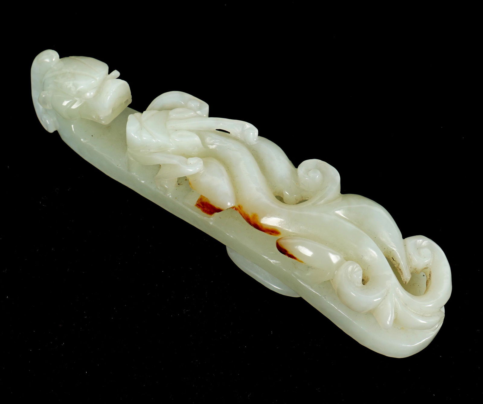 Chinese Carved Jade Dragon Belt Hook: Celadon jade with traces of russet, full figural dragon on body, dragon head hook, 4.25" x 1" x 1".