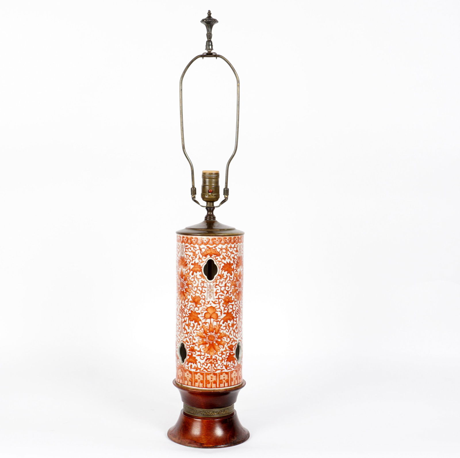 Chinese Iron Red Hat Stand Mounted as a Lamp: Reticulated iron red hat stand body with bats and foliate scroll designs, turned wood base, embossed brass collar, single socket fixture. Overall 30.75" h. x 6" base dia. Condition: Wear to lacquer on