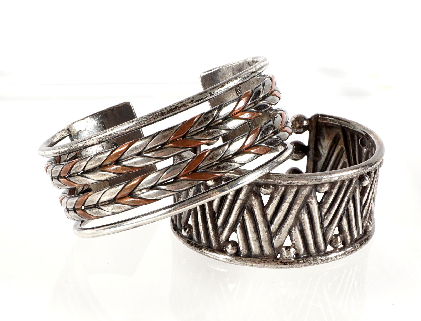 2 William Spratling Mexican Silver Bracelets: Two pieces total from Mexican silver artist William Spratling to include 1) Reticulated mixed metal with copper, 980 silver, 2 5/8" interior width, 2 1/4" inside width, 1.25" wide. 2) Reticulated cros