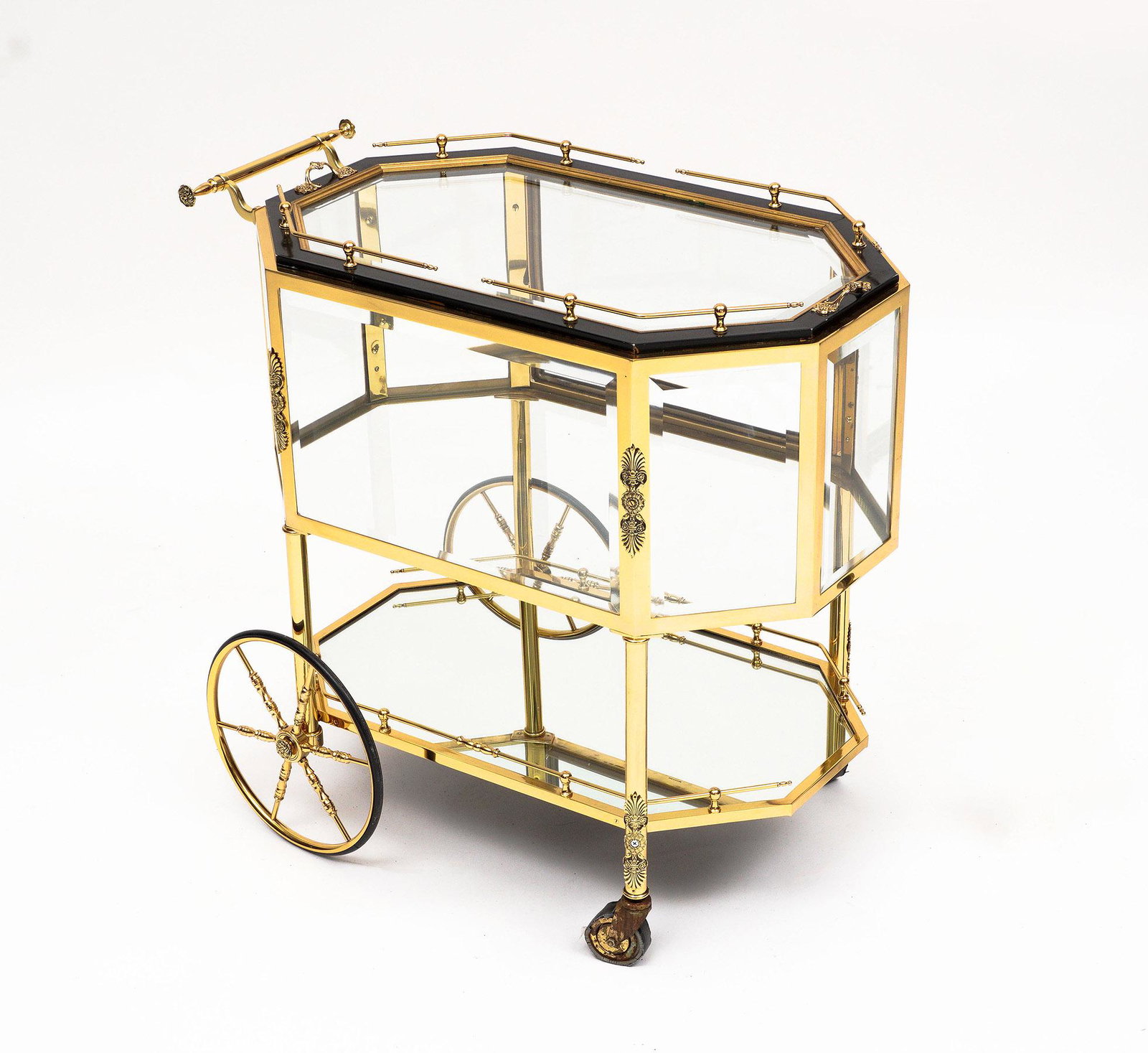 French Brass Trolley Bar Cart: Two tier cart with brass rails frame, supports, and handles, beveled glass top over encased vitrine storage compartment, mirrored lower shelf, rubber lined brass wheels. Restored condition, overall 31