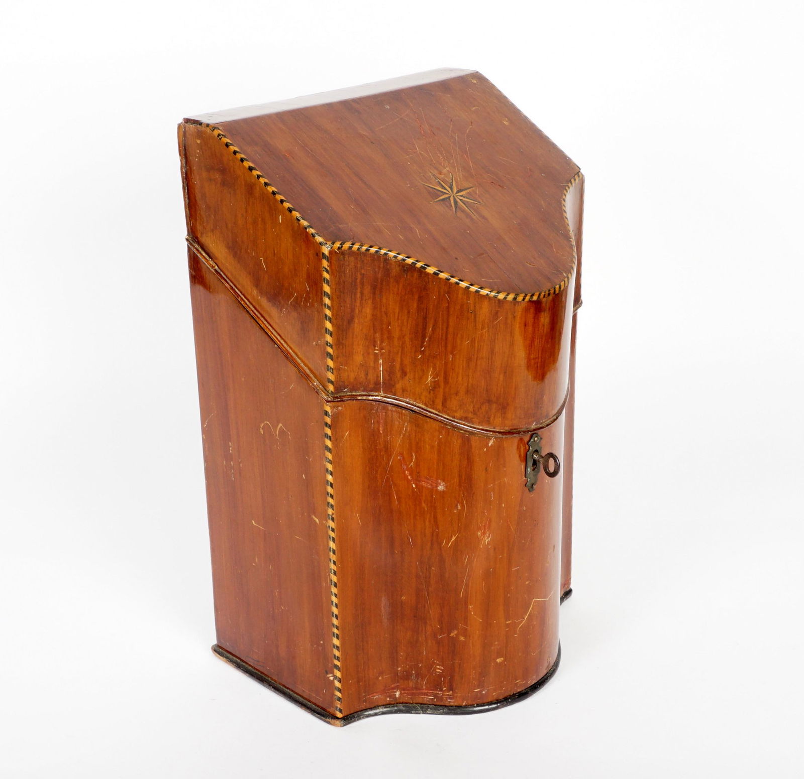 English Regency Inlaid Mahogany Knife Box: Hinged lid with star and rope twist inlay, serpentine front and top, fitted interior. Overall 14" h. x 9" x 7.25". Condtion: Scratches and dings.