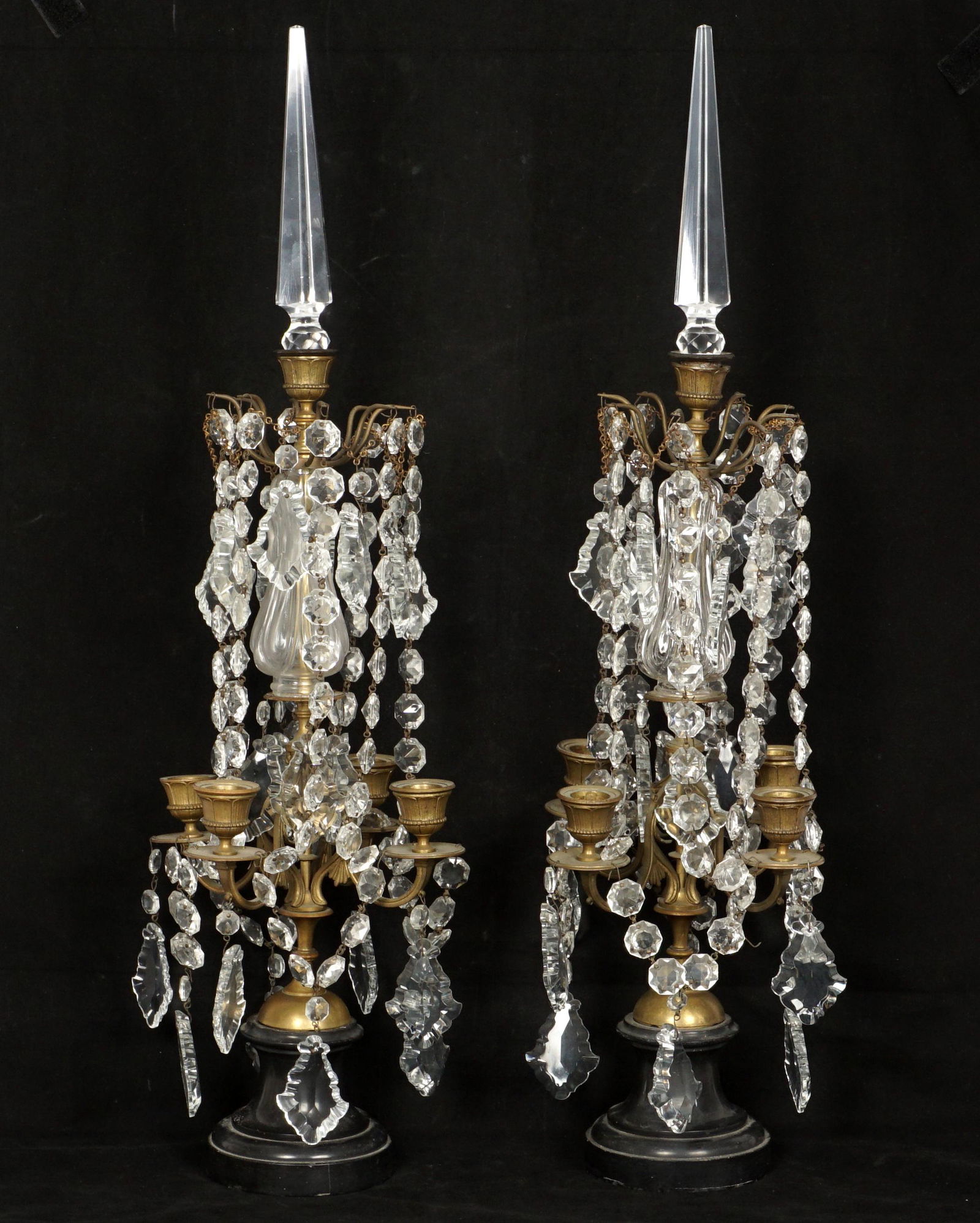 Pair French Brass and Crystal Table Chandeliers: Removable crystal spire finial, single center lot top, four arms, faceted crystal swags and drops, slate bases. Overall with finial 27" h. x 8.5" dia. Condition: The occasional chip to crystal may be