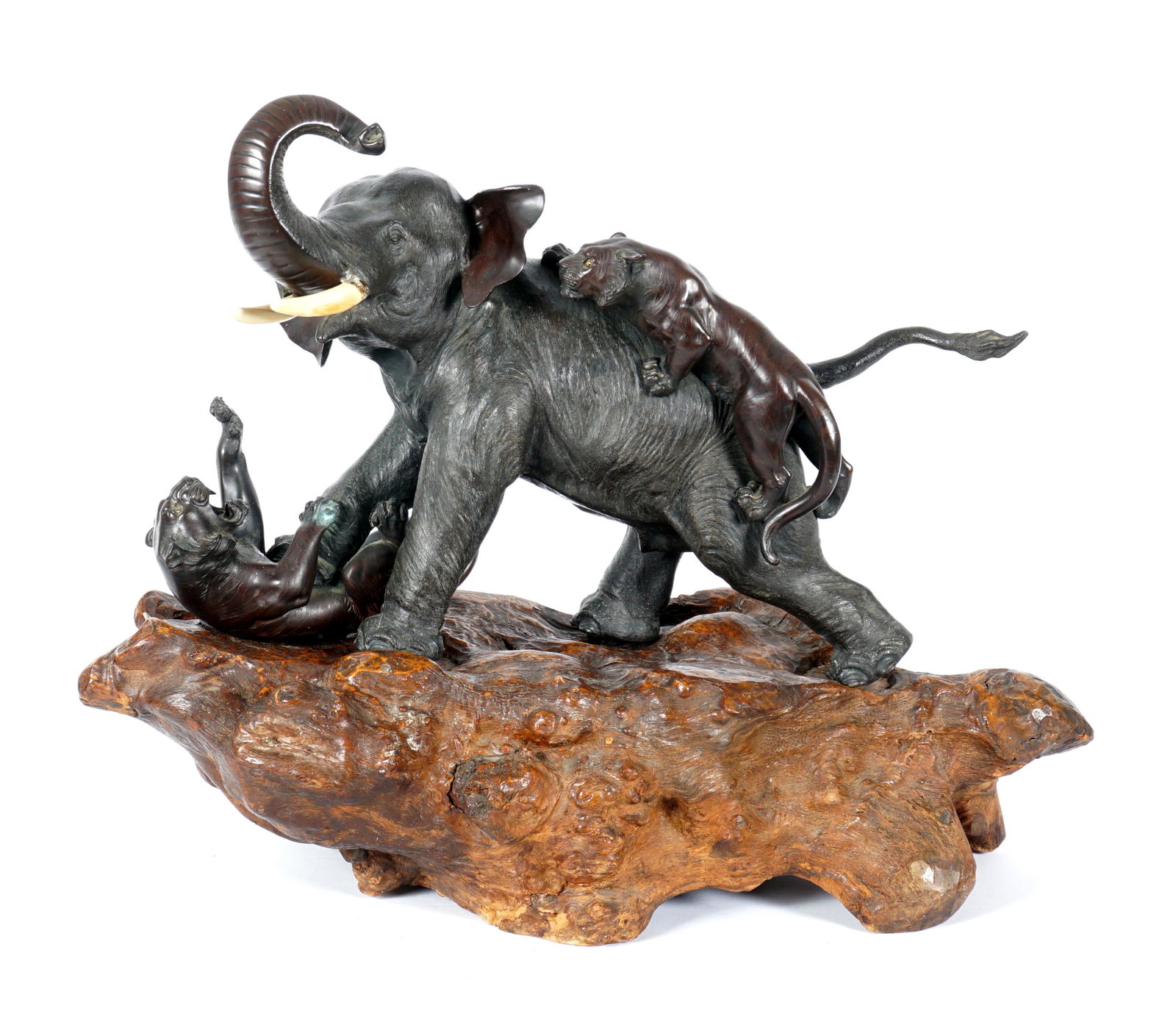 Meiji Style Bronze Elephant Fighting Tigers: Bronze figure of an elephant fighting off two tigers, bone tusks, unsigned. Overall measures 14.25" h. x 22" x 8.5". Sold with fitted wood base, 7.5" h. x 28" x 12.5". Condition: Uneven finish, repair