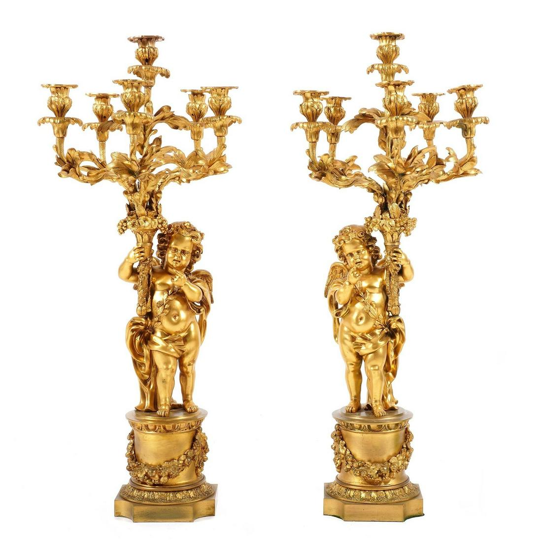 Pr French Large Gilt Bronze Cherub Candelabra: Seven lights with foliate branch supports figural cherub holding bouquet, pedestal base with applied decoration, overall 33.5" h. x 14" dia. From the estate of a prominent lawyer from New Rochelle, NY