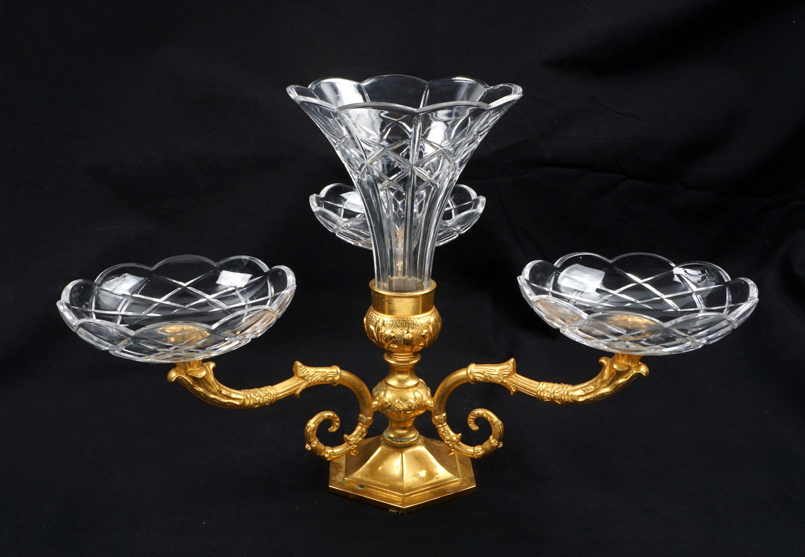 Italian Gilt Bronze and Crystal Epergne: Center cut clear glass floriform vase, gilt bronze base with three scroll arms, each supporting a scalloped round cut clear glass bowl, marked under foot. Overall 9.25" h. x 14" Condition: Minor spott