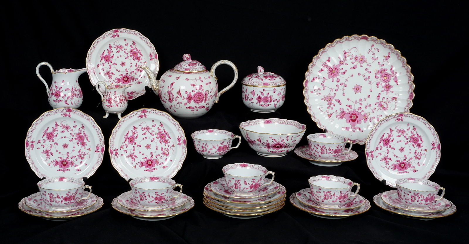 31 Piece Meissen Pink Floral Tea Service: 31 pieces total in a pink floral pattern by Meissen, marked with blue crossed swords, to include teapot with lid and flower finial (6" h. x 9", chips to flower), 7 teacups (2" h.), 6 saucers (6" dia.)