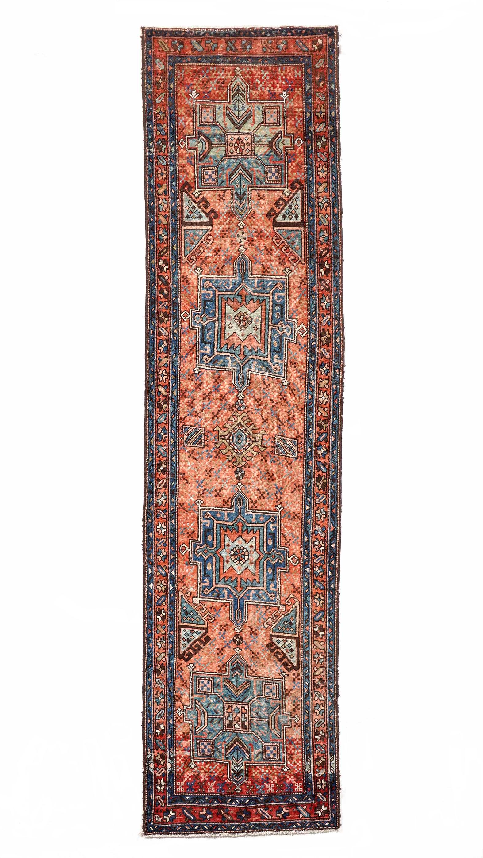 Heriz Persian Runner Rug: Three foliate and geometric border bands, salmon pink ground field with four geometric medallions, 2' 9" X 11' 6". Wool warp, please see photos for condition.