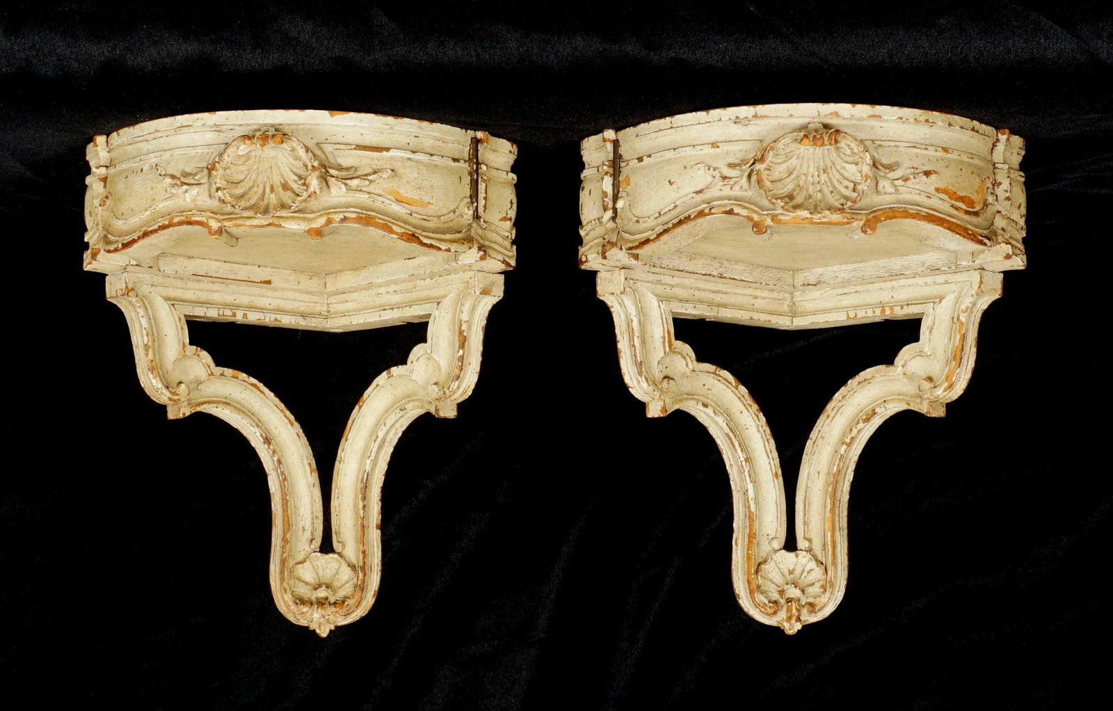 Pair French Paint Decorated Corner Wall Brackets: 19th / 20th Century pair paint decorated corner wall brackets with single side hinge drawer, shell carved fronts, shaped lower support with shell carving, overall 12.25" h. x 10.75" x 10.5". From the