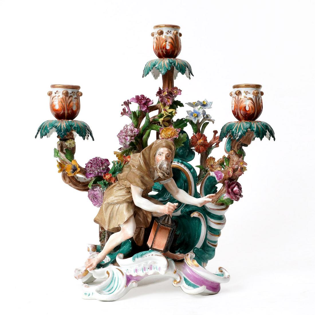 Meissen Style Figural Porcelain Candlestick: Figure of a man holding a lantern, three branch arms, applied flower all over, altered blue crossed swords mark underneath. Overall measures 11.75" h. x 10" x 5.5". Condition: Chips, repairs, and loss