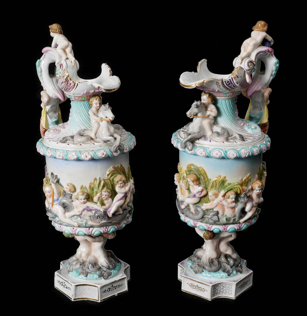 Pair Meissen Style Figural Porcelain Ewers: Matched pair with figural putti, mermaids, satyr, merhorses, and dolphins, unidentified mark on base of one. Overall 14.5" h. x 7". Condition: The occasional fleabite chip. From the estate of a promin