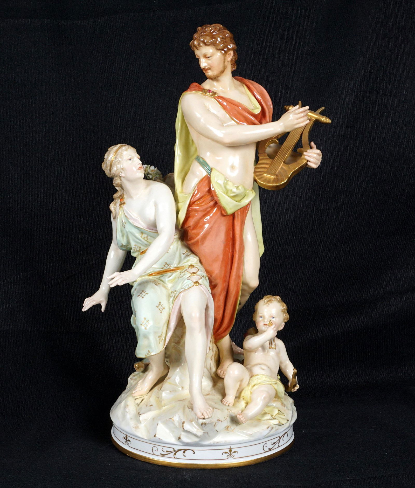 KPM Porcelain Orpheus & Eurydice Figural Group: Figural group of Orpheus and Eurydice, man holding a cithara, seated woman, and two cherubs, red KPM stamp and blue scepter mark under base. Overall 13.5" h. x 7" dia. Condition: Repair to woman's han