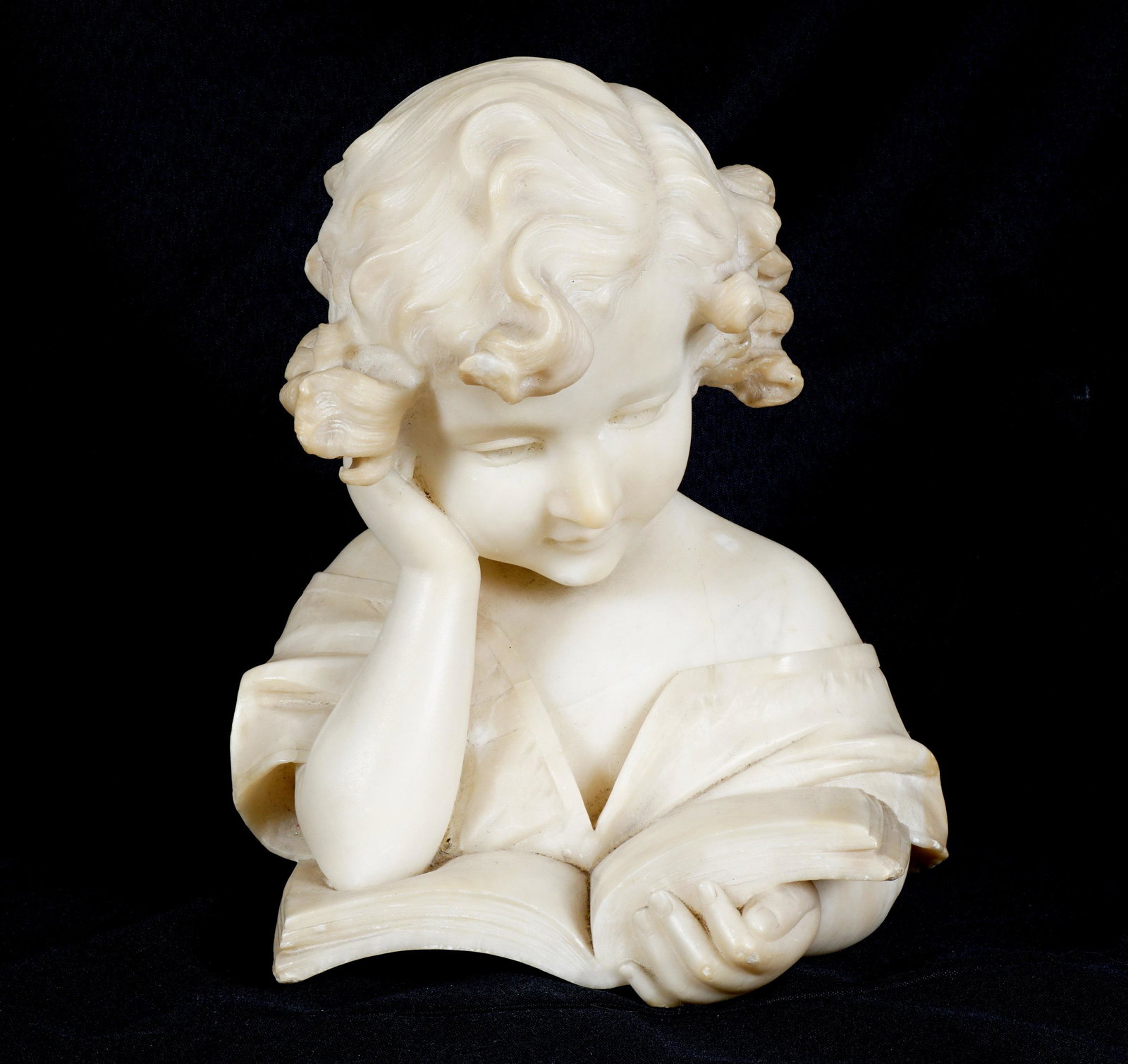 Alabaster Sculpture of Girl Reading a Book: Carved alabaster bust of a young girl reading a book, unsigned, 10.5" h. x 9.5" x 8". Condition: Minor chips. From the estate of a prominent lawyer from New Rochelle, NY.