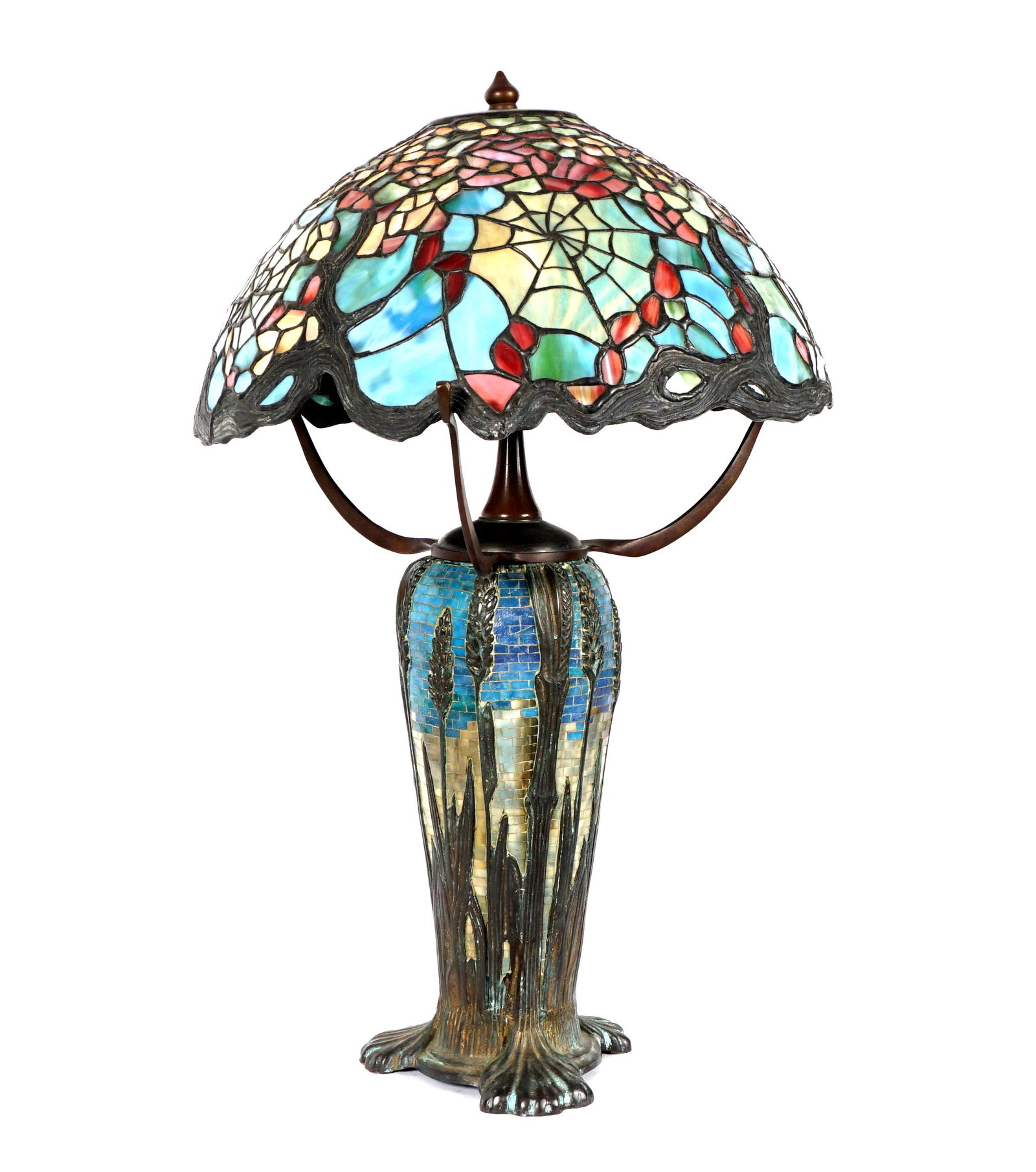 Tiffany Style Mosaic Base Leaded Glass Shade Lamp: Bronze and mosaic tile base, triple socket fixture, unmarked. Floral cobweb leaded and stained glass shade. Base measures 21" x 17.75" dia., shade 9"5" h. x 17.75". From the estate of a prominent lawy
