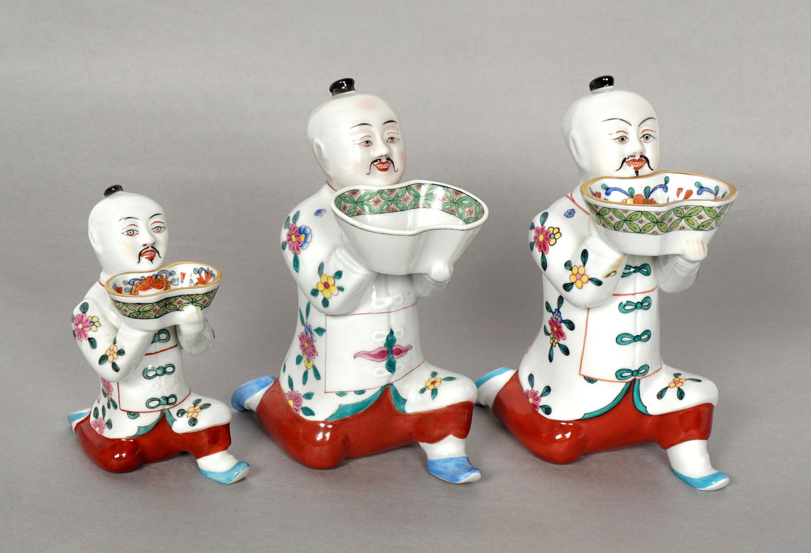Three Herend Porcelain Mandarin Figural Salts: Three pieces total, each figure of a Chinese man kneeling holding a salt cellar, two measure 6.5" h. x 3" x 4.75", the other 4.5" h. x 2.25" x 3.5". From the estate of European collector Mark Melamud
