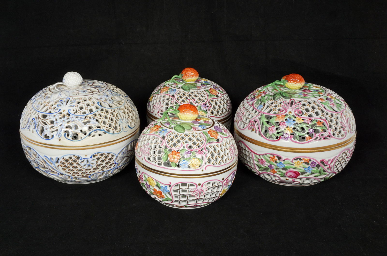 Four Herend Porcelain Reticulated Potpourri Jars: An assembled collection of four jars total, two large, two smaller. Three polychrome decorated, the fourth blue, white, and gilt decorated. Larger measures 6.5" h. x 7.5", smaller 5.75" h. x 6". Each