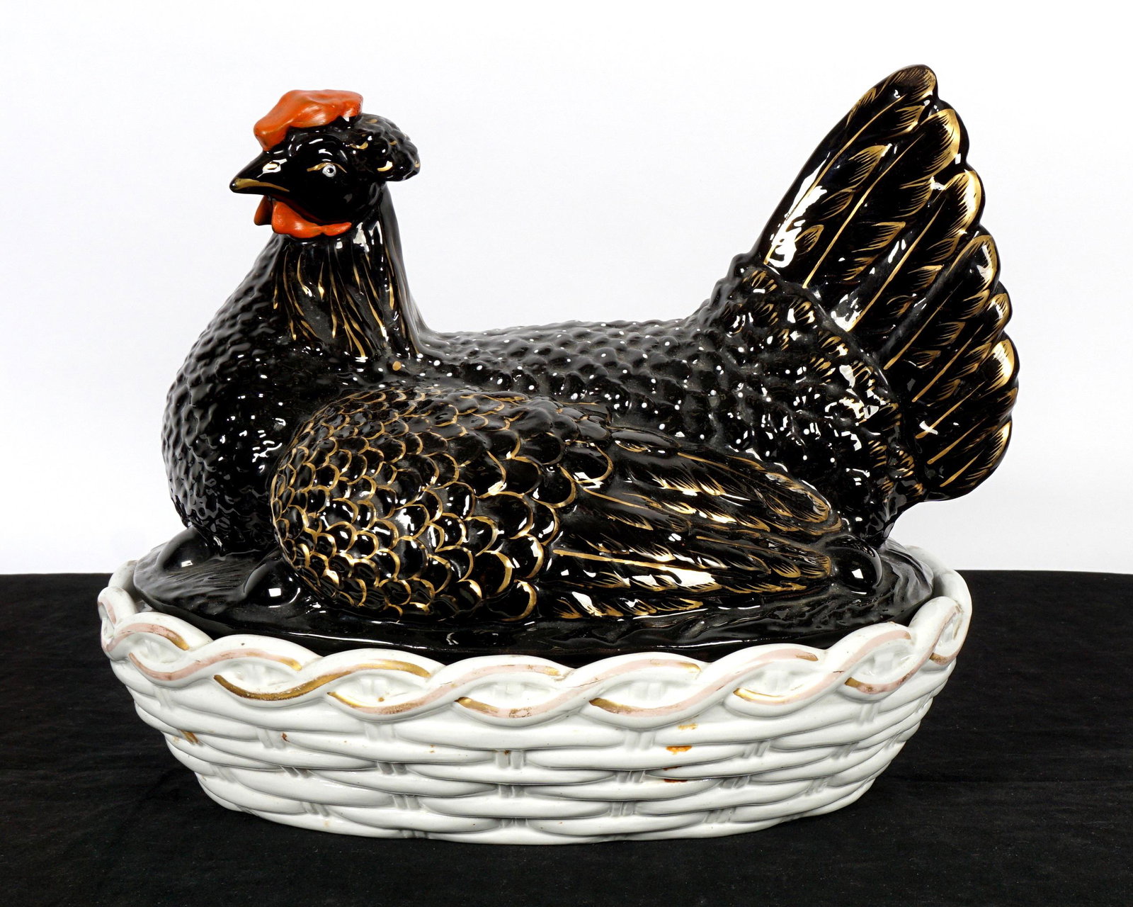 Large Staffordshire Hen on Nest: Black hen with gilt accents, red comb, white basket, unmarked, 12.25" h. x 15.5" x 11.25". Condition: Rim chips and wear to decoration.