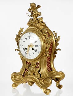 French Tiffany & Co. Gilt Bronze Mantle Clock: Heavy gilt bronze case with figural cupid figure finial, floral and foliate scroll, lattice sides with silk backing. White enamel dial with Roman and Arabic numerals, marked Tiffany & Co. Samuel