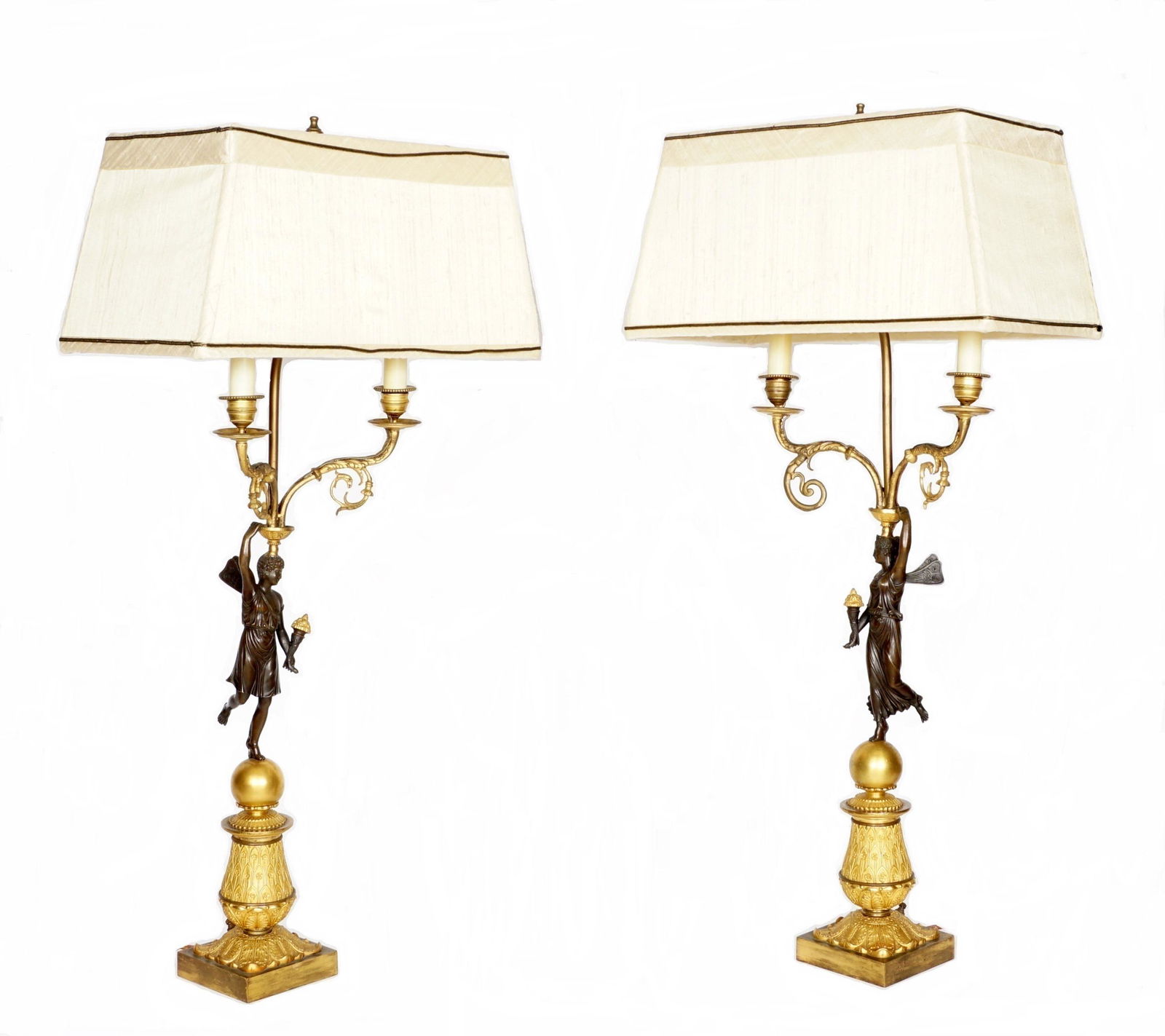 Pair French Bronze Figural Candelabra Lamps: Patinated bronze figural maiden two gilt bronze scroll arms, gilt bronze base, electrified, no visible markings, 32.5" h. x 10.5". Sold with white linen shades, 7.75" h. x 16.25" x 8.5". Condition: Sp