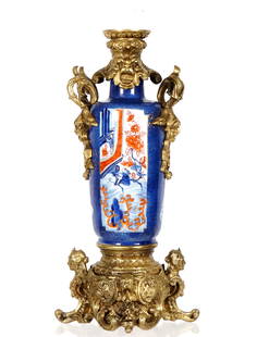 Gilt Bronze Mounted Porcelain Vase Lamp Base: Gilt mounted bronze top and base with masks, foliate scroll, and busts. Porcelain vase with Chinese motifs in reserves, gilt accents, no visible markings. Overall 16" h. x 8" x 6". From the estate of