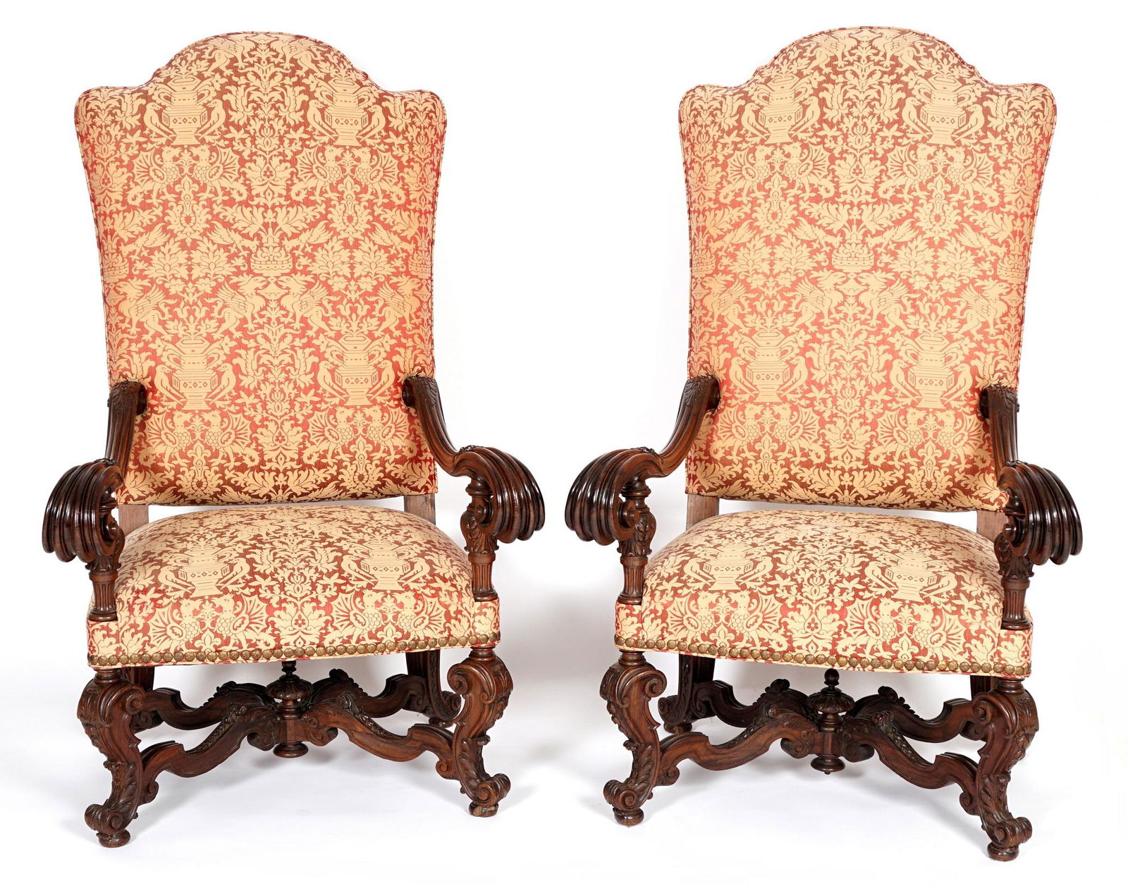 Pair Palatial 19th Century Portuguese Rosewood Arm Chairs: Palatial throne chairs, each with acanthus leaf carved, shaped, and fluted arms ending in scroll hand holds. carved and shaped legs and stretchers, tacked patterned upholstery featuring dragons, birds